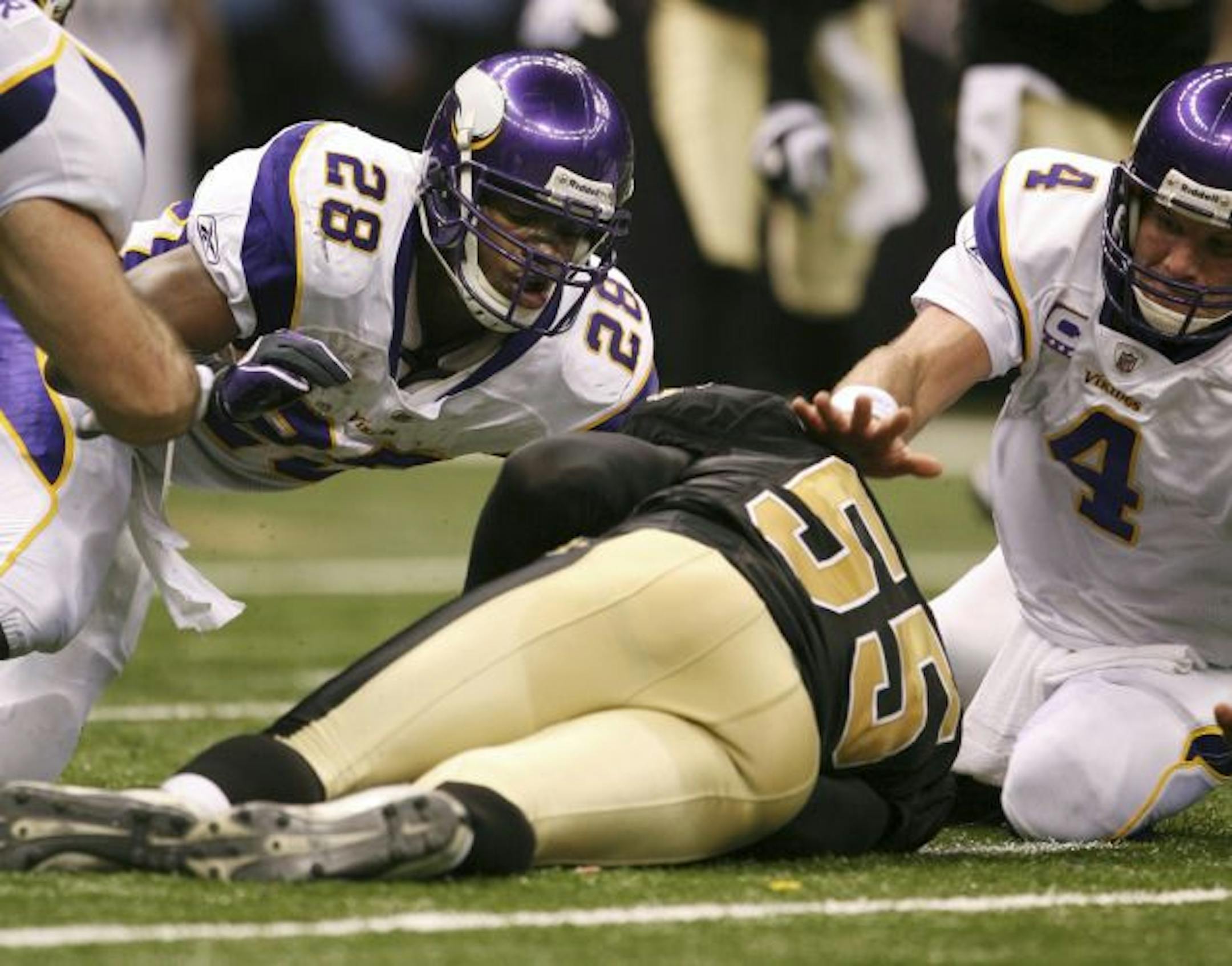 Saints linebacker Scott Fujita (55) beat Vikings running back Adrian Peterson (28) and Brett Favre to the ball after a botched handoff late in the first half Sunday — one of several costly Vikings turnovers at pivotal moments.