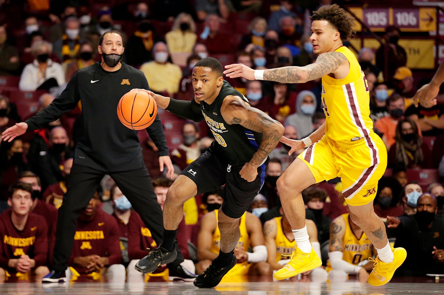 Purdue Fort Wayne guard Jalon Pipkins (50) drives against Minnesota guard Sean Sutherlin (24) and forward Charlie Daniels (15) in the first half of an NCAA college basketball game, Friday, Nov. 19, 2021, in Minneapolis. (AP Photo/Andy Clayton-King)