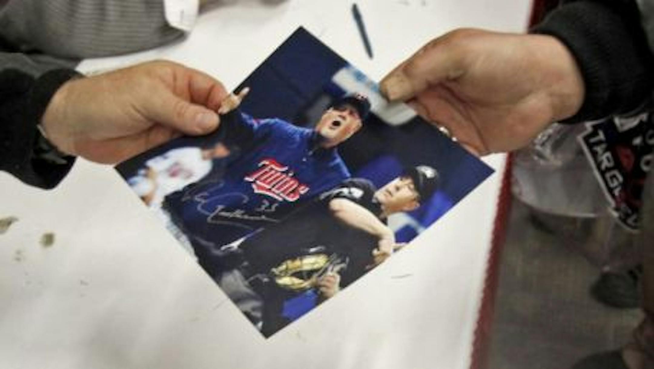 DAVID JOLES  • djoles@startribune.com -Jan. 28, 2011- Blaine, MN-] Twins Fest 2011 was moved from the Metrodome to the National Sports Center in Blaine and kicked off Friday with an autograph session with Twins catcher Joe Mauer. In this photo:] Twins manager Ron Gardenhire, left, hands over an autographed photo of him getting tossed from a game to a fan who brought the photo to get signed.
