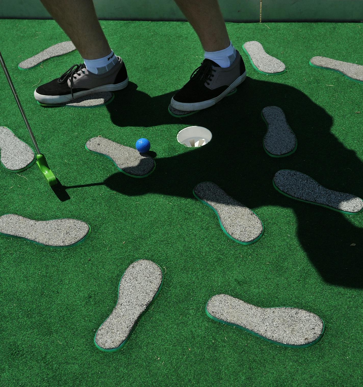 To celebrate the 25th anniversary of the Minneapolis Sculpture Garden Walker Art Center's Artist-Designed Mini Golf is now in play. The number 9 hole is called" Be A Sculpture" where players are encouraged to stand on the feet pedestals when putting] Richard.Sennott@startribune.com Richard Sennott/Star Tribune. , , Minnesota Monday 6/3/13) ** (cq)