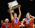 Elk River forward Sidney Wentland (25) hoisted the 4A championship trophy above her head as she marched toward the student section with teammates, inc