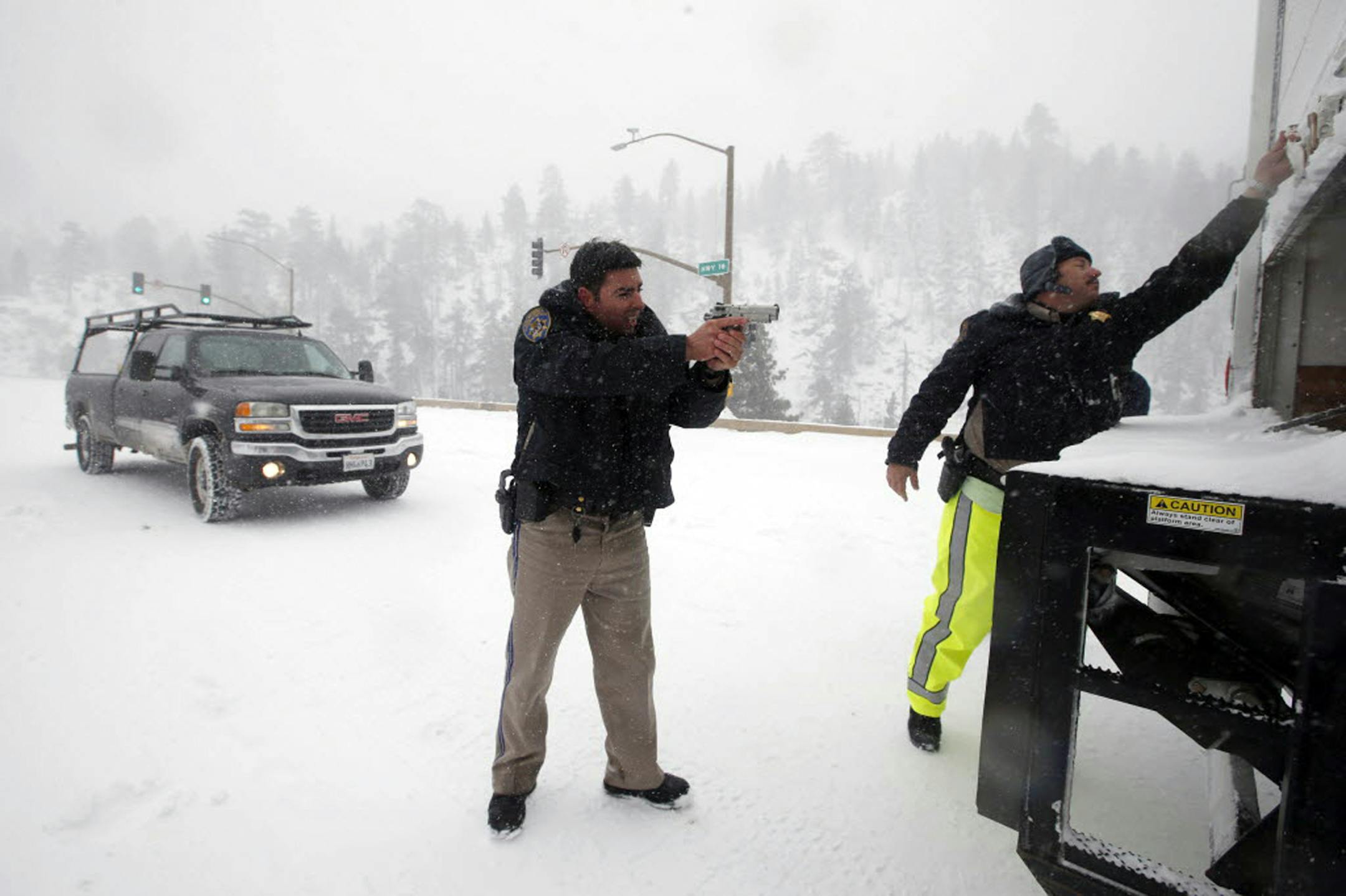 California Highway Patrol officers search a truck for former Los Angeles police officer Christopher Dorner at a checkpoint near Big Bear Lake, Calif, Friday, Feb. 8, 2013. Law enforcement officers working in falling snow searched the Southern California mountain for Dorner, who is accused of carrying out a killing spree because he felt he was unfairly fired from his job.
