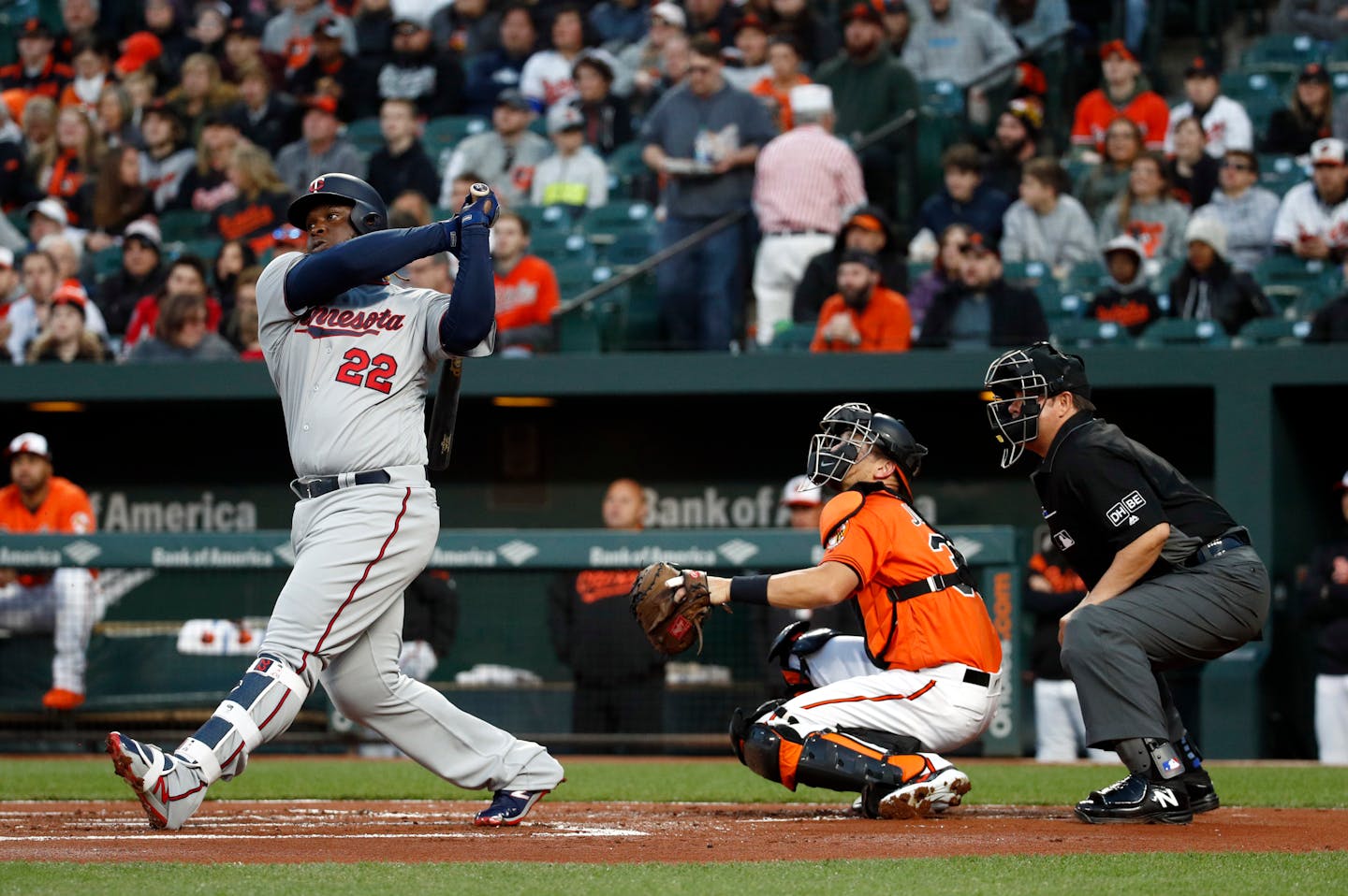 Minnesota Twins' Miguel Sano, left, watches his solo home run in front of Baltimore Orioles catcher Caleb Joseph and home plate umpire Doug Eddings in the first inning of a baseball game, Saturday, March 31, 2018, in Baltimore. (AP Photo/Patrick Semansky)