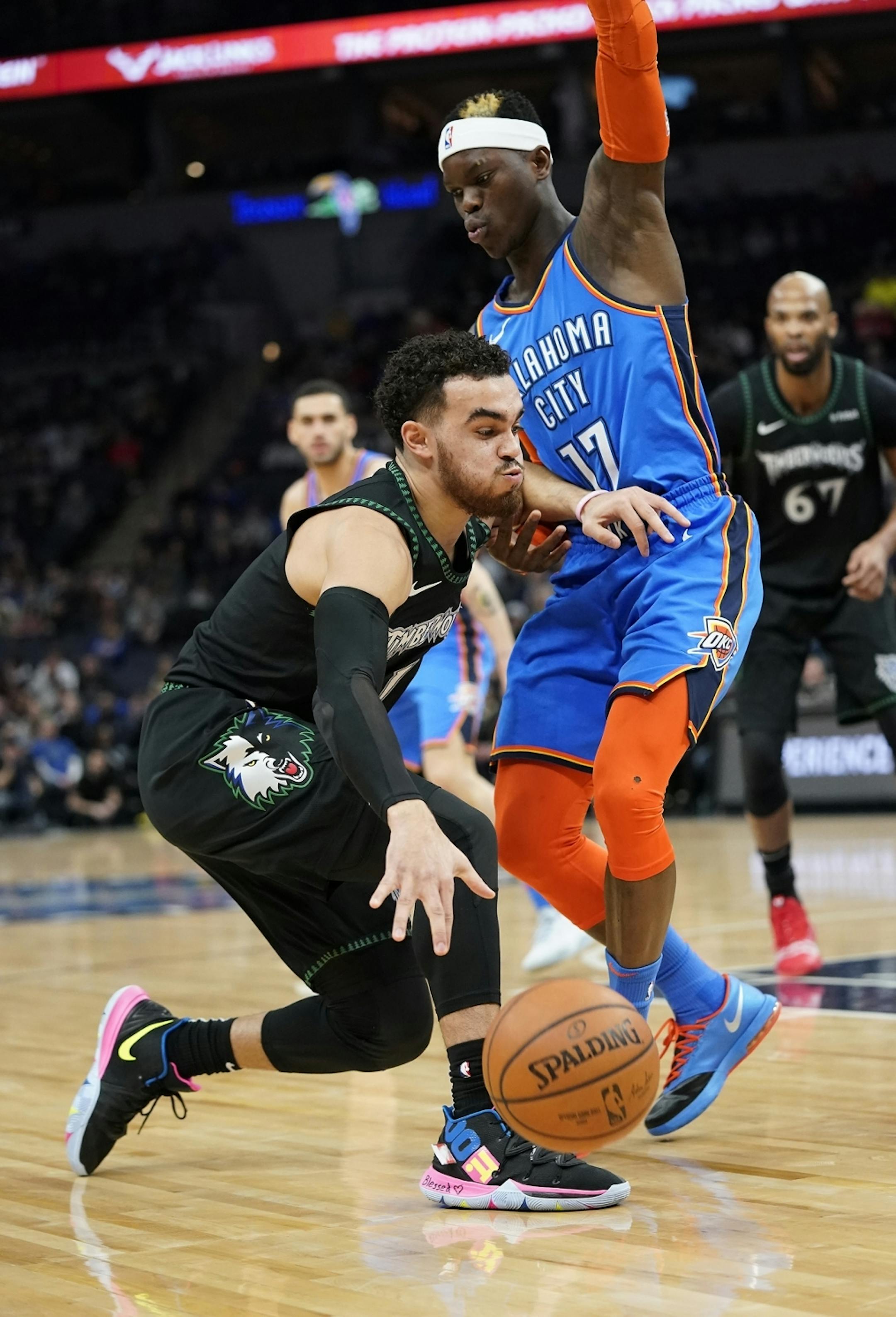 Minnesota Timberwolves guard Tyus Jones (1) drives with the ball as Oklahoma City Thunder guard Dennis Schroder (17) defends during the first half.