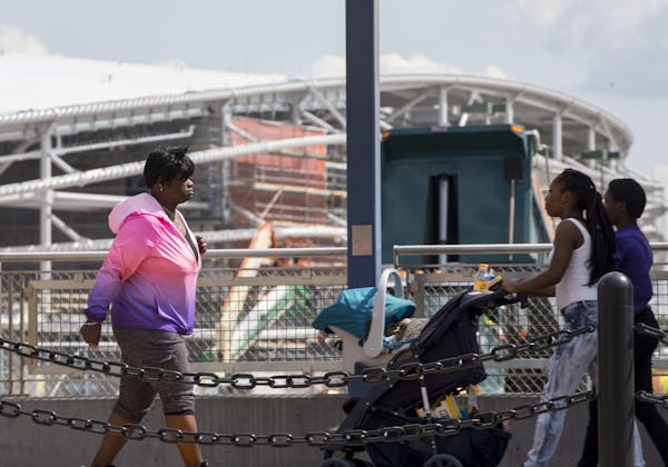 Pedestrians moved along a light rail platform in the Midway district as construction progresses on Minnesota United's Allianz Field.