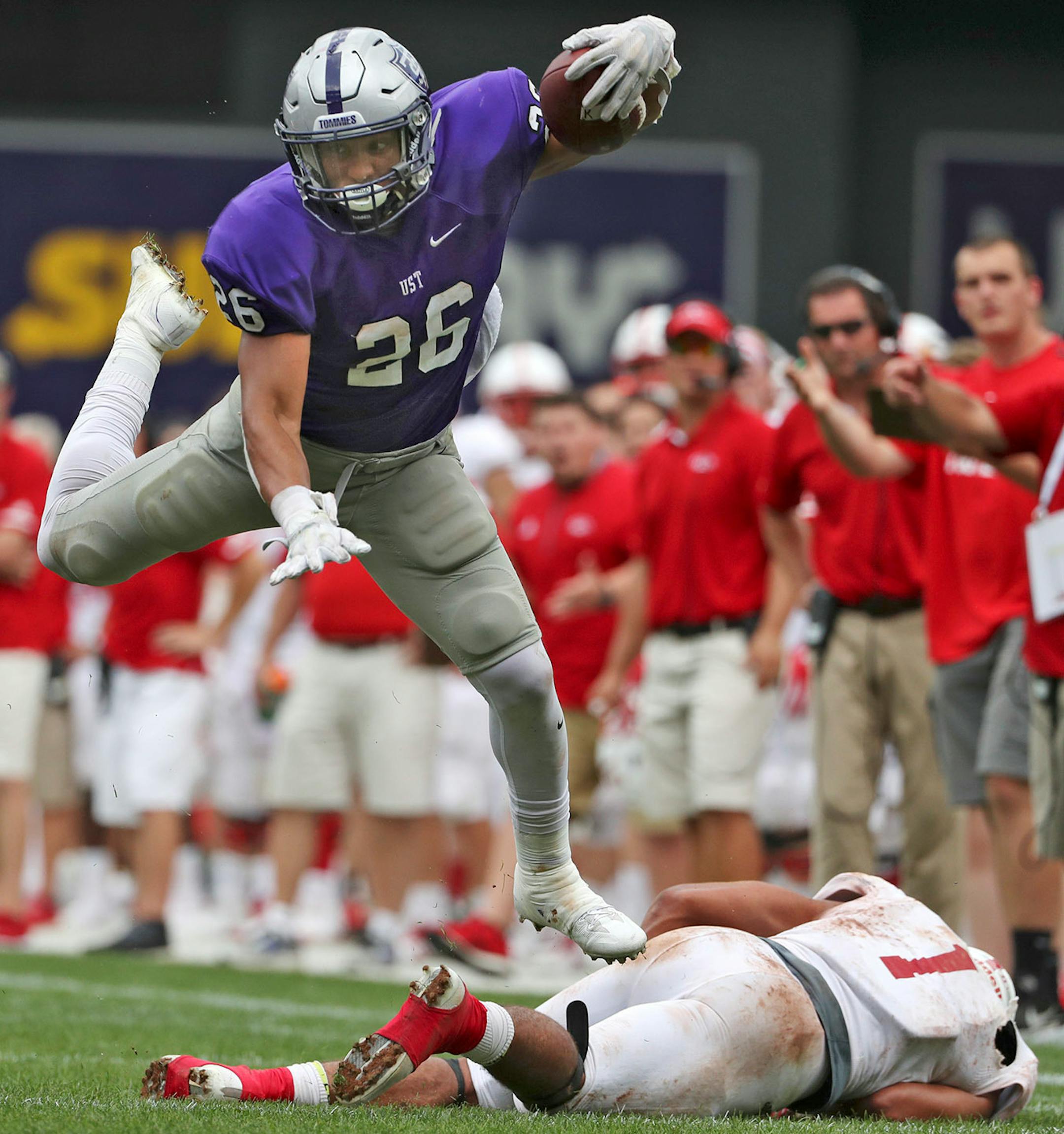 University of St. Thomas running back Josh Parks (26) leapt over St. John's University defensive back Max Jackson (1) as he ran the ball in the second half.