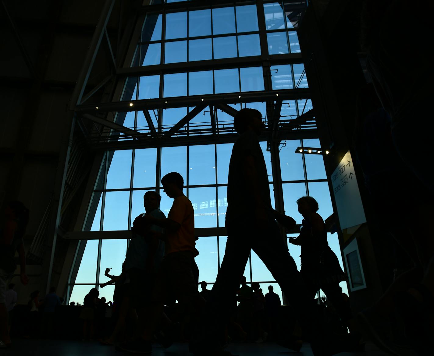 People were silhouetted by the windows on the upper concourse before Wednesday night's game at US Bank Stadium. ] (AARON LAVINSKY/STAR TRIBUNE) aaron.lavinsky@startribune.com US Bank Stadium opened its doors for its first sporting event Wednesday, as AC Milan played Chelsea FC on Wednesday, August 3, 2016 in Minneapolis, Minn.