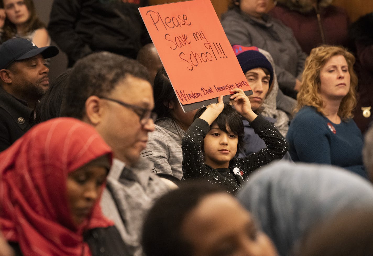 Andree Athorn, 5, a student from Windom Dual Immersion School, held a sign during the Minneapolis school board meeting Tuesday night.