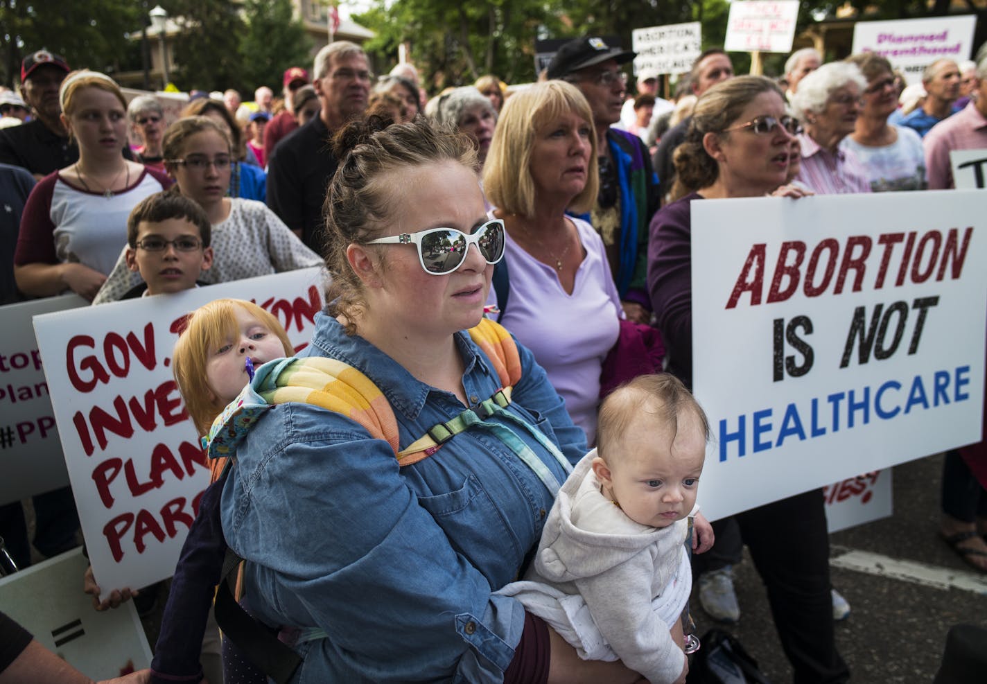 In front of the governor's mansion in St. Paul, pro-life activists gathered to ask Gov. Mark Dayton to investigate Planned Parenthood and calling for legislators to defund the organization. Kacey Porter of Hastings with her daughters Roxanna, 3 months, and Penelope,3, came because they do not want tax payers funding Planned Parenthood.]Richard Tsong-Taatarii/rtsong-taatarii@startribune.com