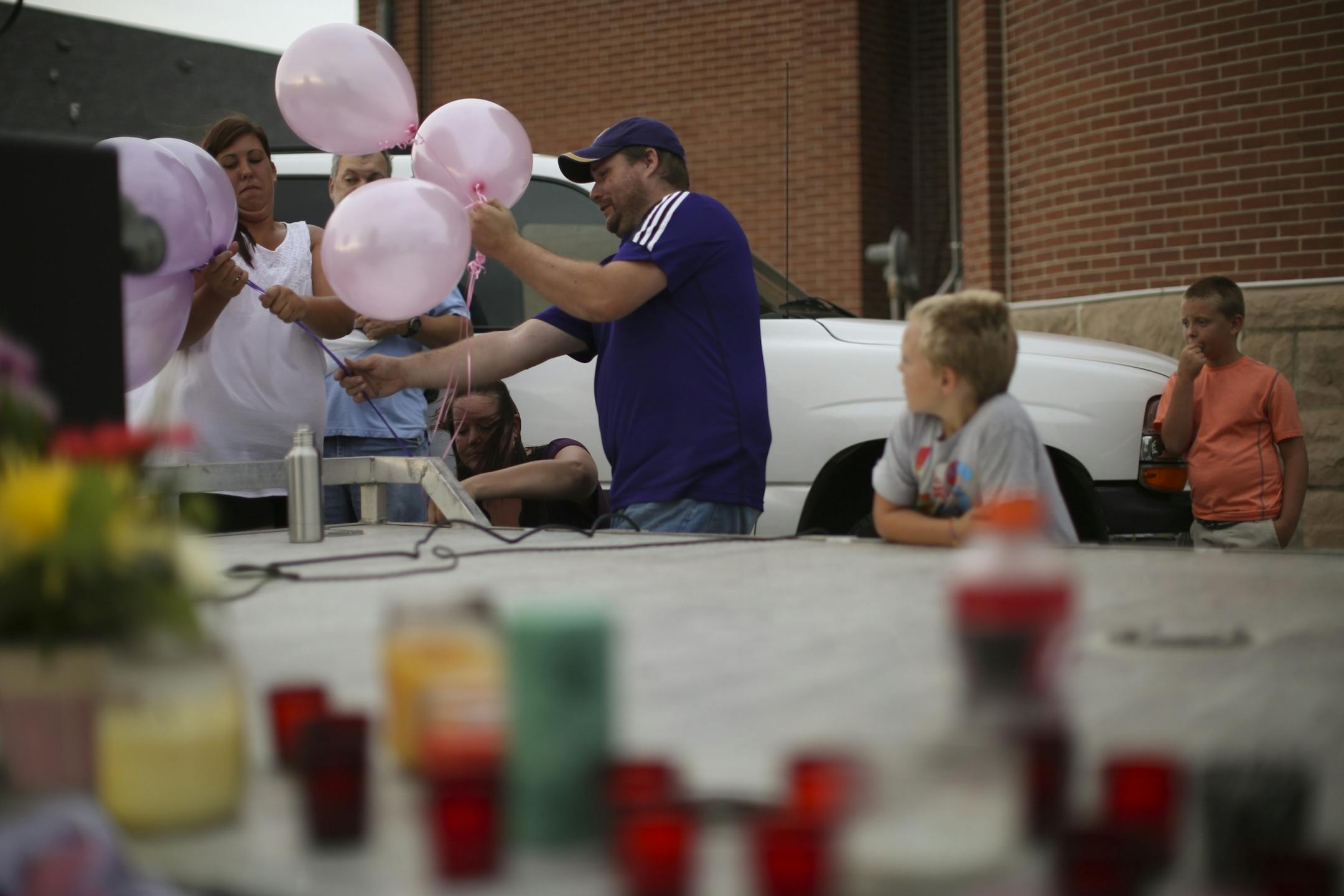 Volunteers set up balloons as they prepared for the vigil for Alayna Ertl Tuesday night in the parking lot of St. Anthony Church in Watkins.
