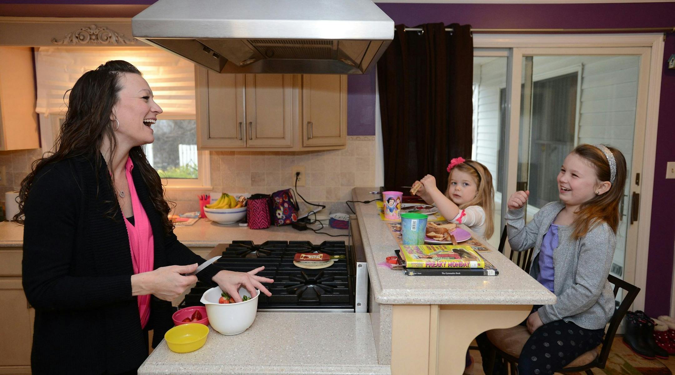 Carrie Hennessy, left, with daughters Caileigh, 7, right, and Leia, 4, in the kitchen of their new home in Ramsey, N.J., Jan. 11, 2014. (Michael Karas/The Record/MCT) ORG XMIT: 1148421