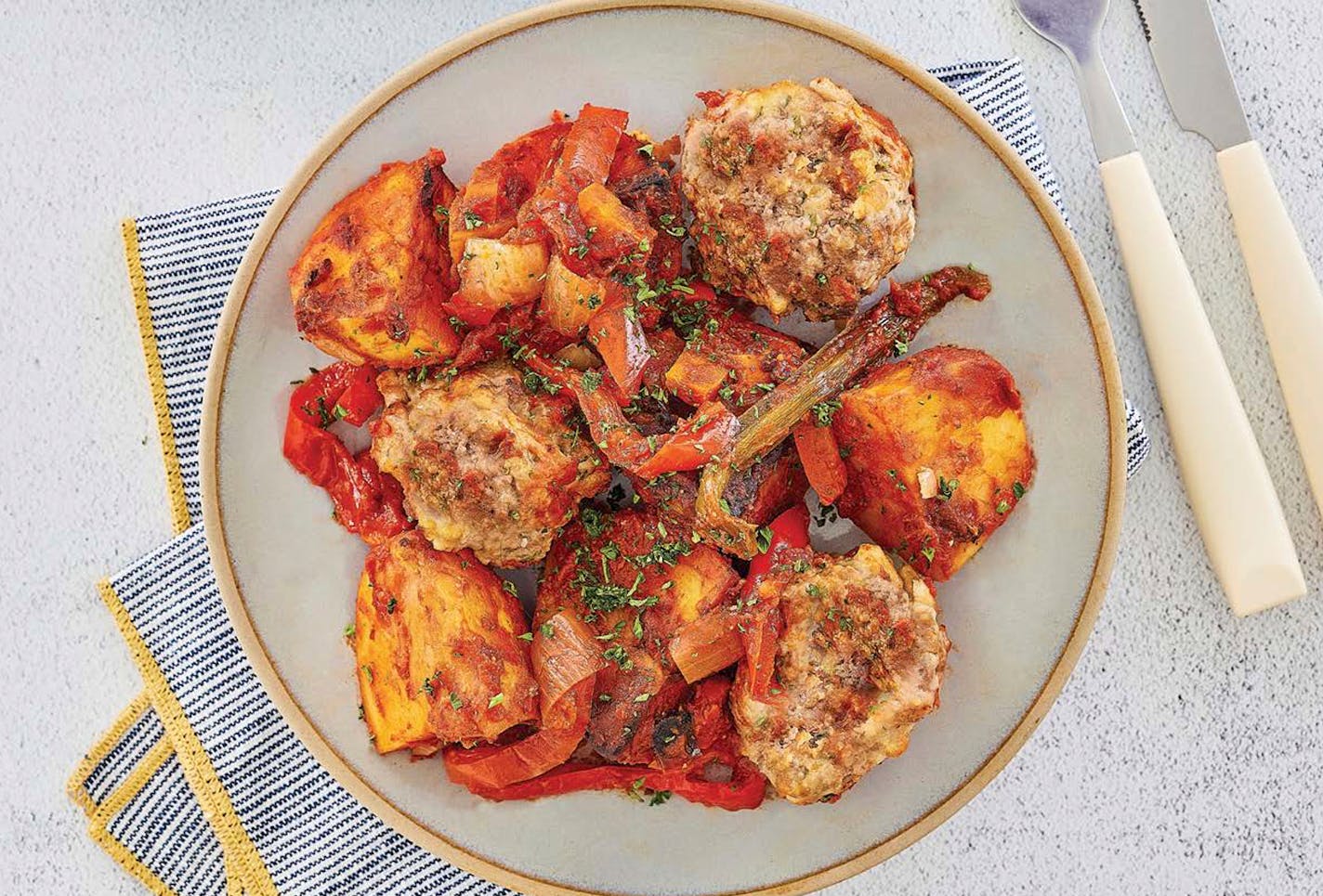 Greek Meatballs with Roast Potatoes, from "The Everything One Pot Mediterranean Cookbook," by Peter Minaki (Simon &amp; Schuster, 2023).Photo credit: James Stefiuk