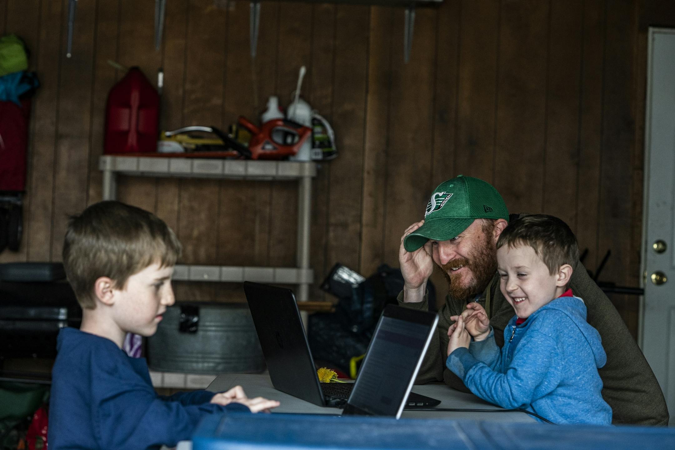 Dan Clapero works with son Franklin(6) on math addition while Calvin(9) reads. Mom is deployed in Kuwait. Her stay has been extended because of Covid-19.