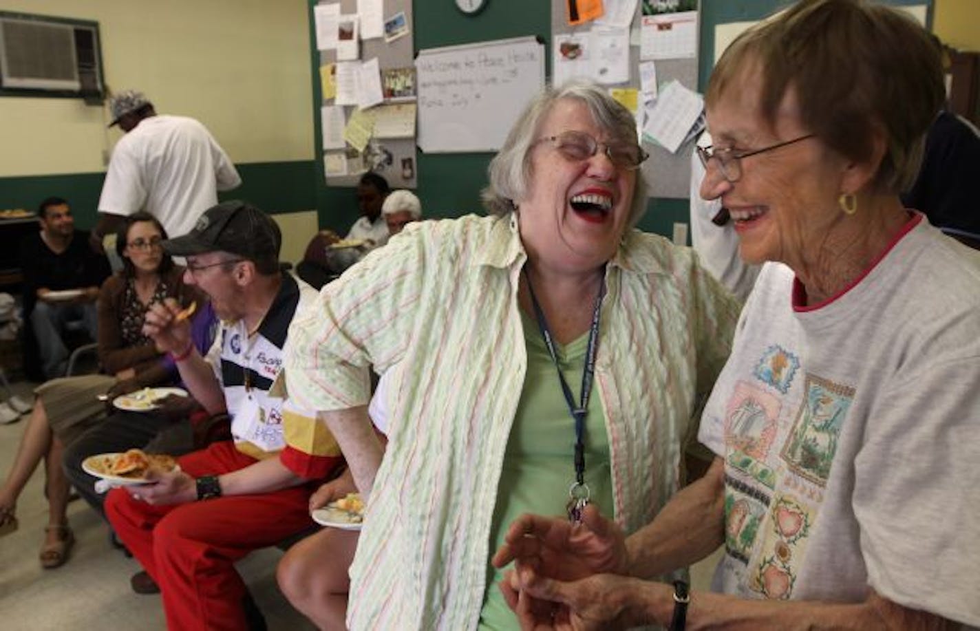 Catherine Mamer, director of Peace House Community, talked with community member K. Cash Luck, right, during lunch at the center.