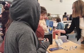 Dakota County Library Deputy Director Jennifer Reichert Simpson hands out stickers and pins at the Kaposia Library’s grand opening on Feb. 20.