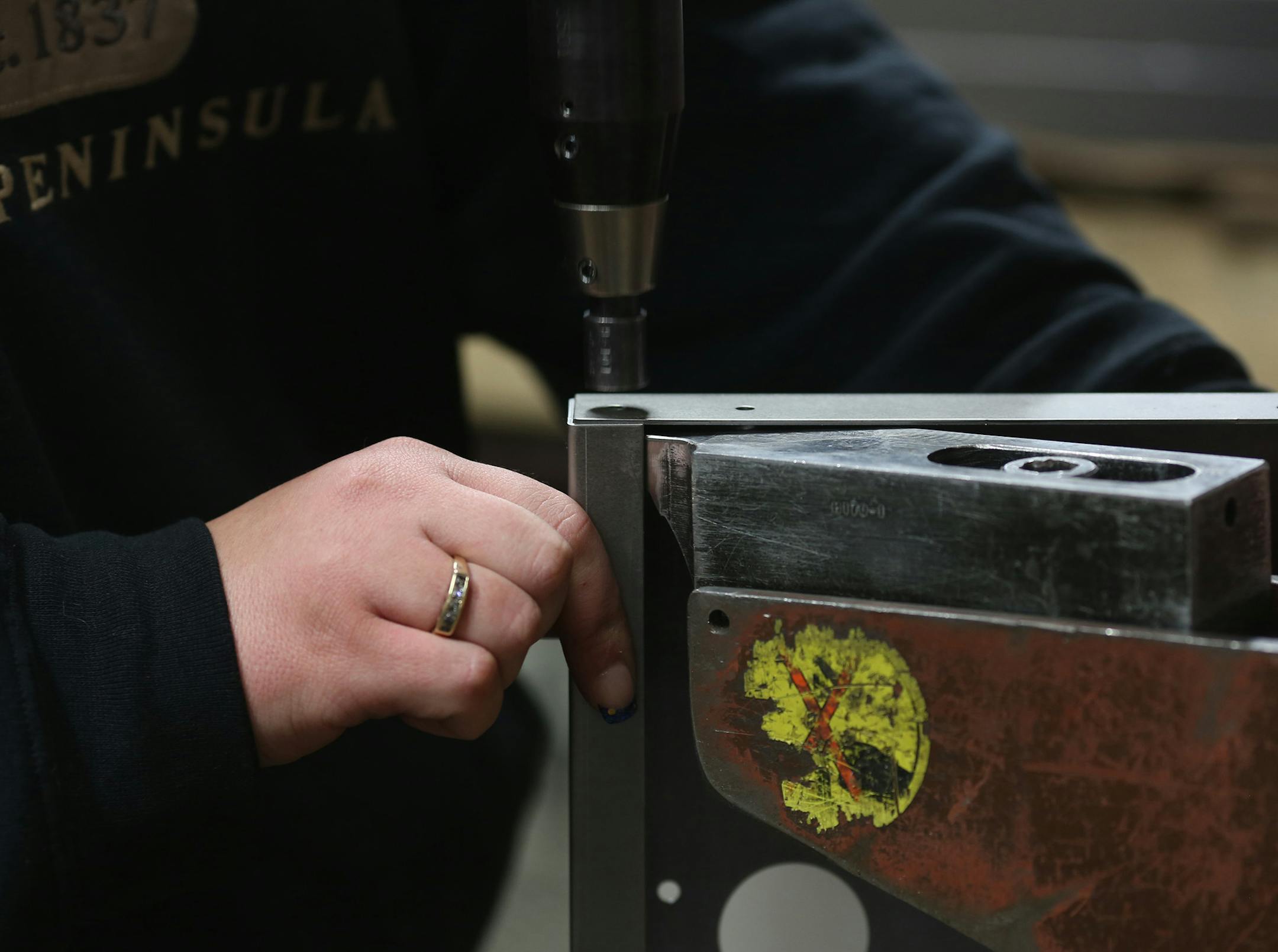 Dani Guy added metal washers on this panel as a part of her work day. ] (KYNDELL HARKNESS/STAR TRIBUNE) kyndell.harkness@startribune.com Wyoming Machine in Stacy, Min., Tuesday, December 9, 2014.