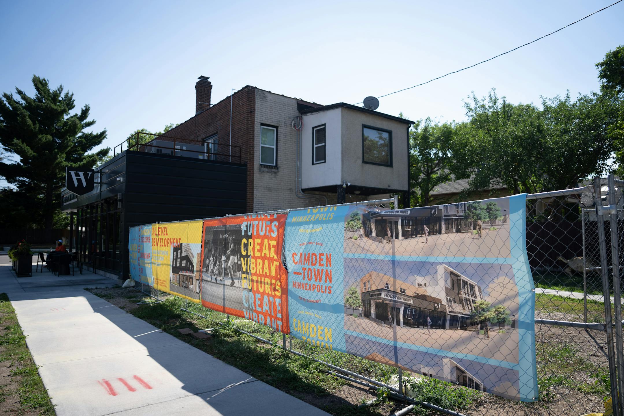Future construction plans are depicted on a sign outside Houston White's building.