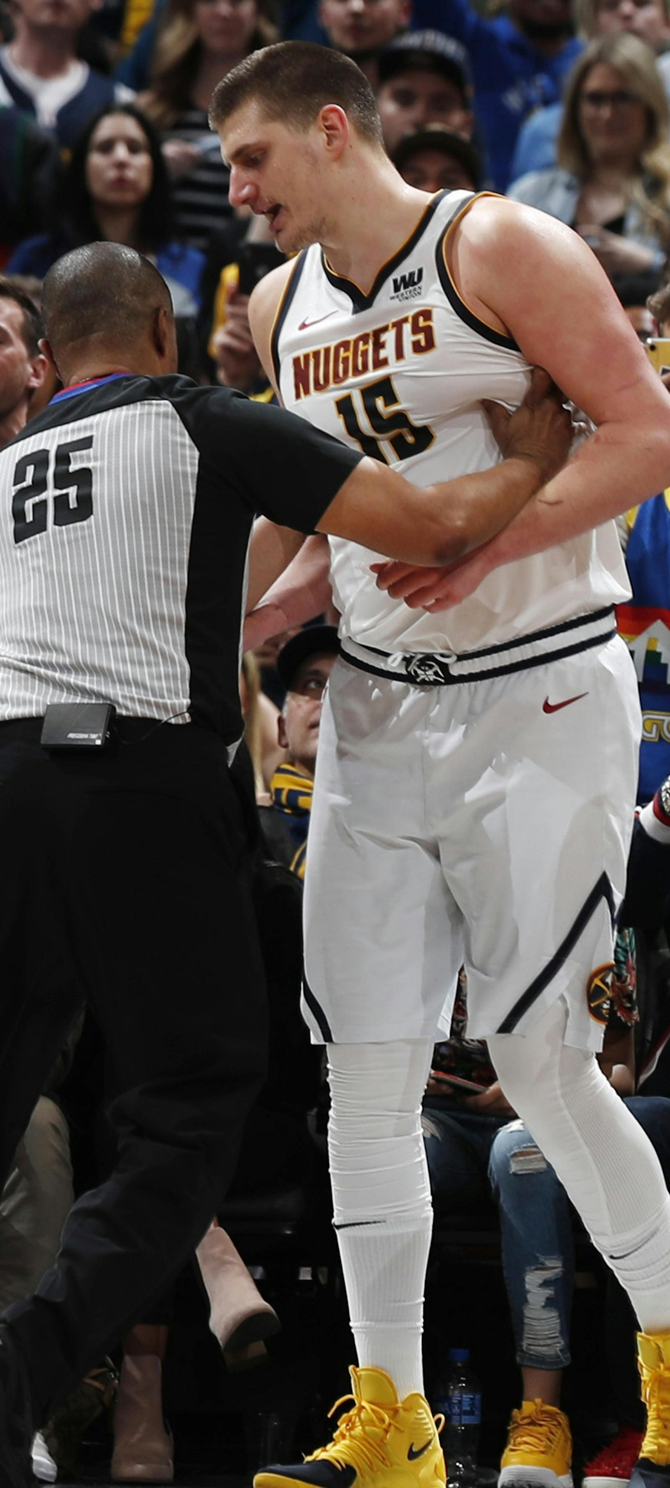 Referee Tony Brothers, left, pushes away Denver Nuggets center Nikola Jokic after Jokic was fouled by Portland Trail Blazers forward Meyers Leonard during the second half of Game 5 of an NBA basketball second-round playoff series Tuesday, May 7, 2019, in Denver. The Nuggets won 124-98. (AP Photo/David Zalubowski)