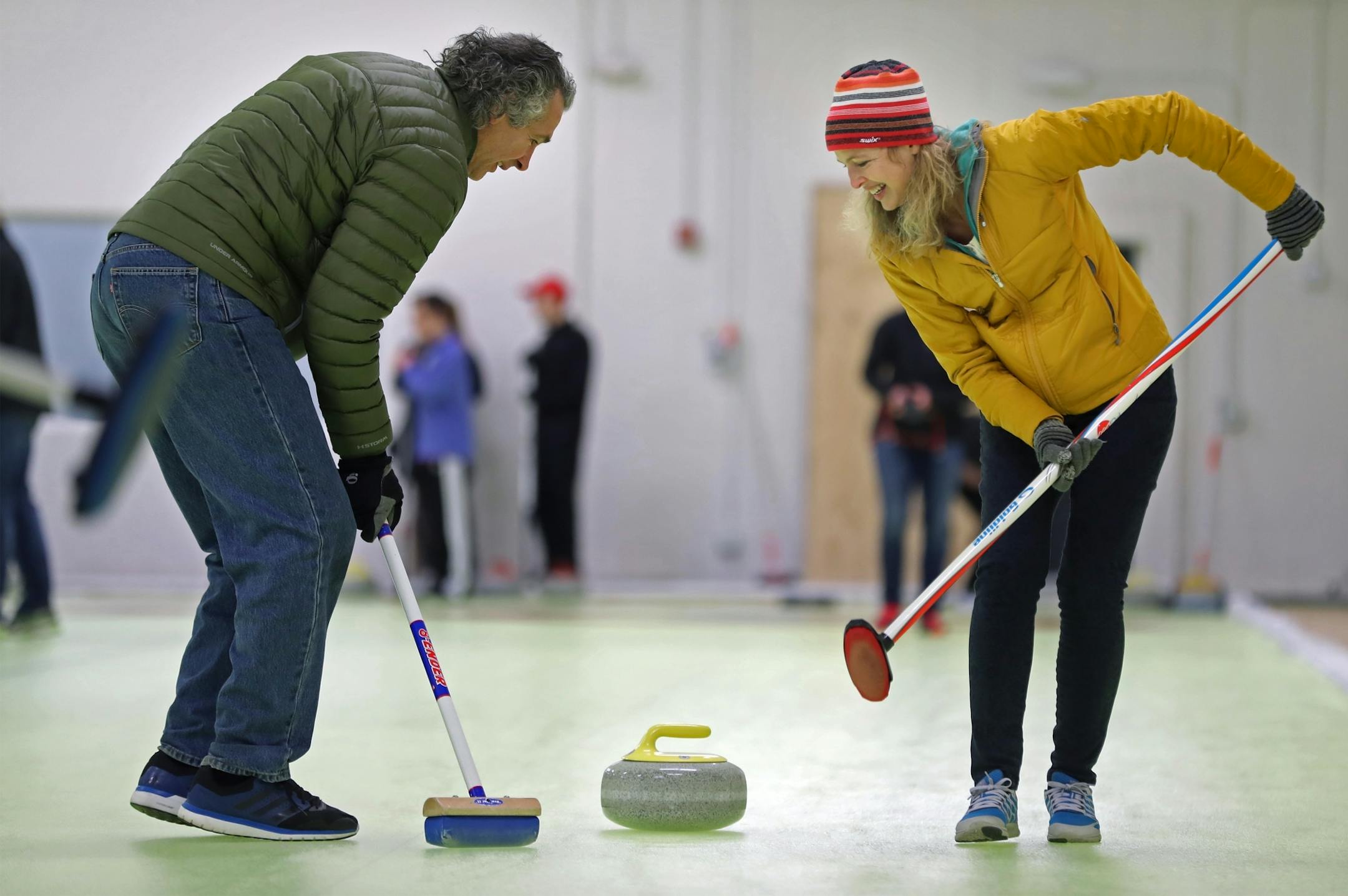 Mike and Kristi Portugue tried to alter the path of the stone to a more favorable path with a broom.