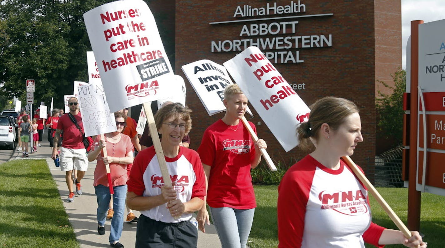 FILE - In this Sept. 5, 2016 file photo, nurses march outside Abbott Northwestern Hospital in Minneapolis to begin an open-ended strike on Labor Day. Nurses at five Allina Health hospitals in Minnesota have voted to approve a labor contract, ending a strike that has dragged on for more than a month. (AP Photo/Jim Mone, File)