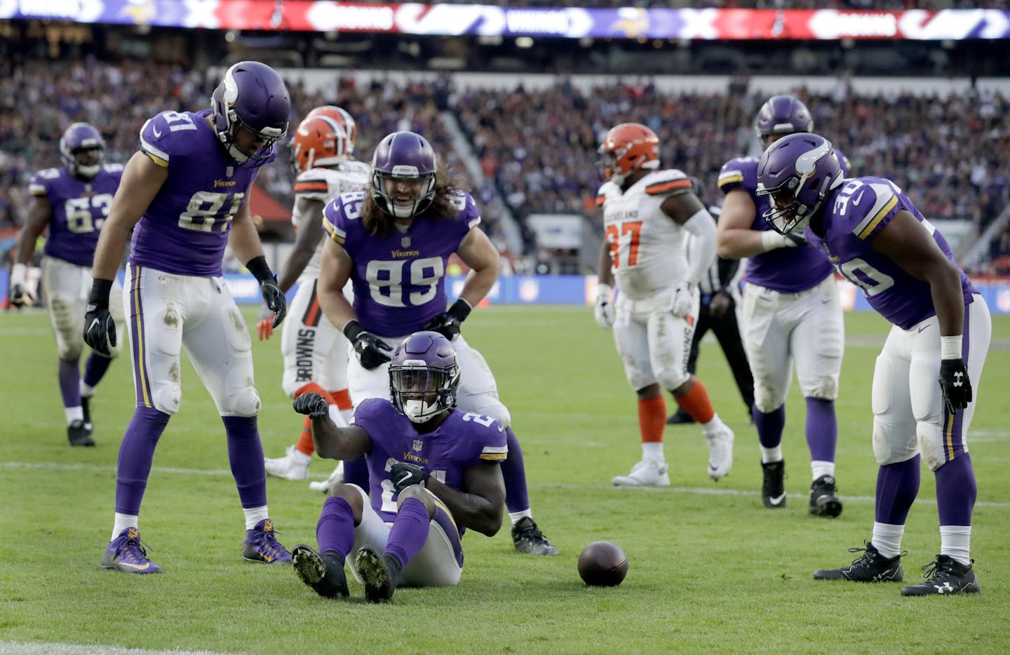 Minnesota Vikings running back Jerick McKinnon (21), center, sits on the turf as he celebrates after scoring a touchdown during the second half of an NFL football game against Cleveland Browns at Twickenham Stadium in London, Sunday Oct. 29, 2017. (AP Photo/Matt Dunham)