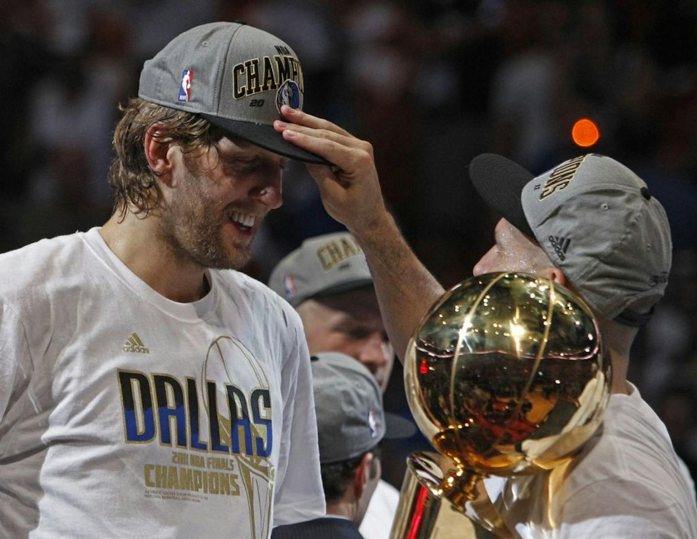 Dallas Mavericks' Jason Kidd looks at the hat of teammate Dirk Nowitzki after Game 6 of the NBA Finals basketball game against the Miami Heat Sunday, June 12, 2011, in Miami. The Mavericks won 105-95 to win the series.