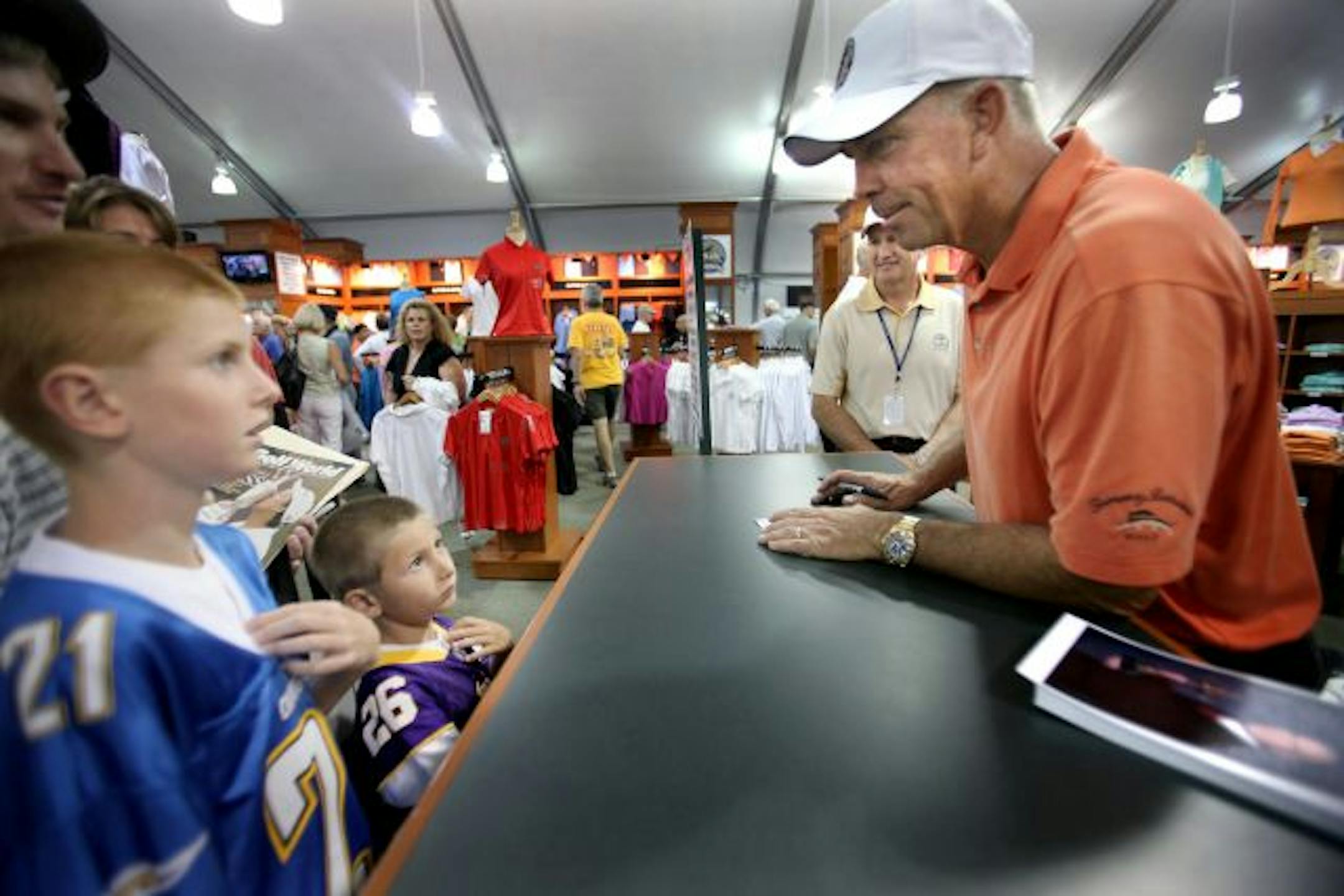 ELIZABETH FLORES � eflores@startribune.com August 8, 2009 - Chaska, MN - Hogan Greenwood, 10, left, and his brother Haden, 6, of Chaska, showed off their pride to Minnesota teams as they spoke with golfer Tom Lehman as he signed autographs at the PGA Championship Golf Shop at Hazeltine for a special Grand Opening. The boys were there with their father Matt Greenwood.