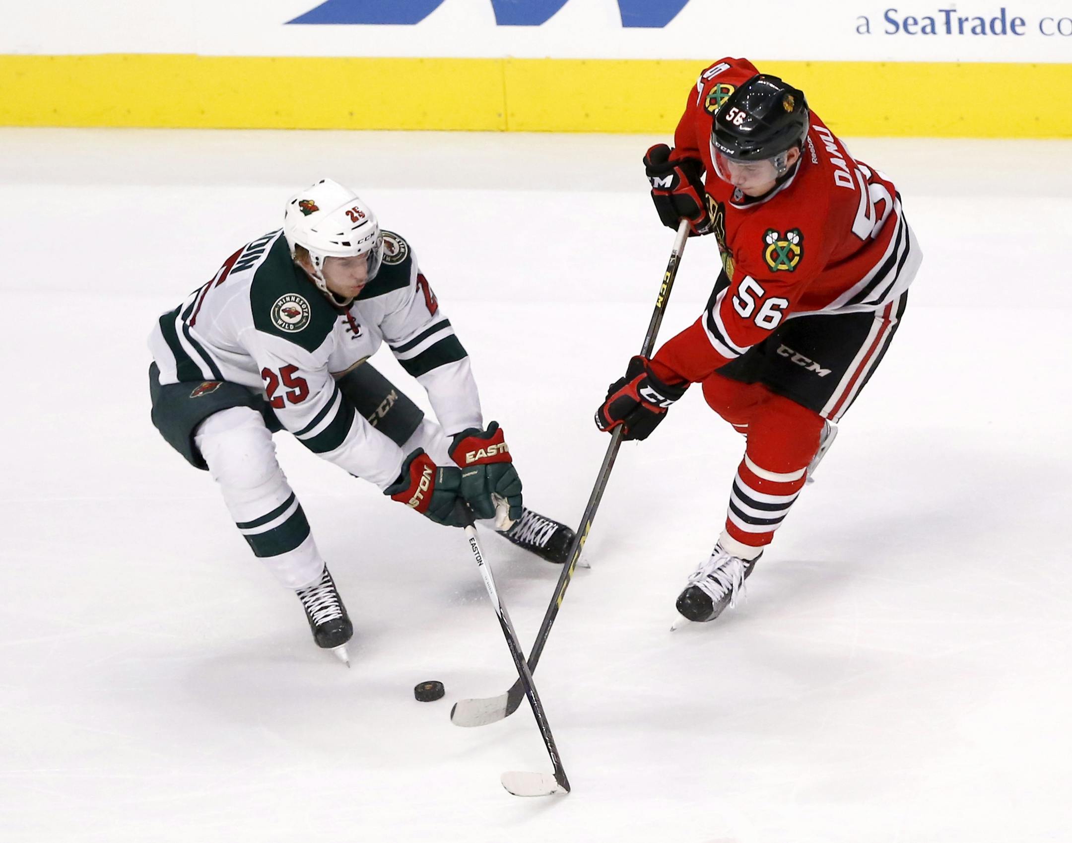 Minnesota Wild defenseman Jonas Brodin (25) and Chicago Blackhawks center Marko Dano battle for the puck during the third period of an NHL hockey game Tuesday, Dec. 1, 2015, in Chicago. The Wild won 2-1. (AP Photo/Charles Rex Arbogast)