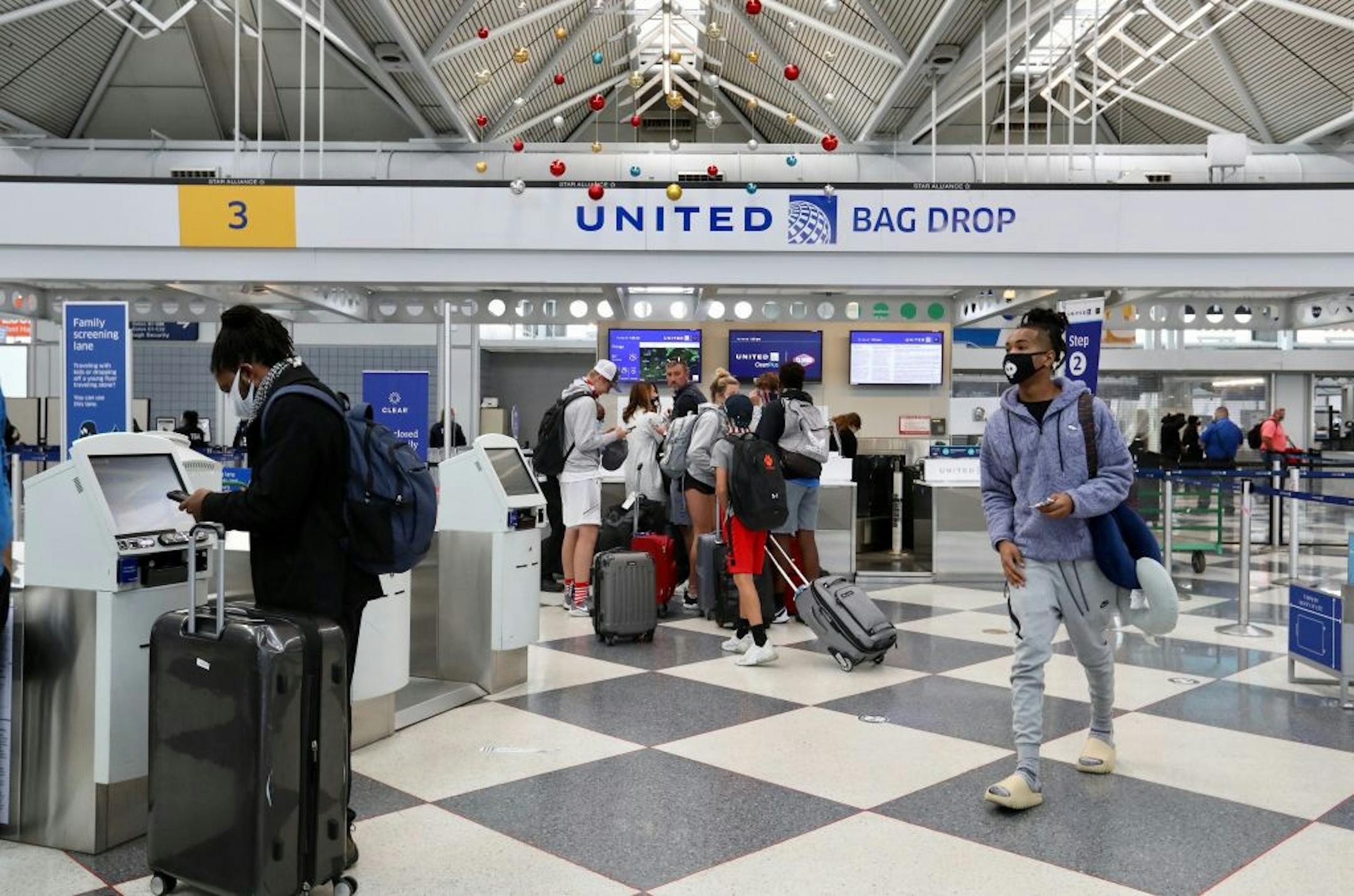 Pre-holiday travelers use kiosks and counters at a terminal at O'Hare International Airport in Chicago on Friday, Nov. 20, 2020. Millions are crowding airports and boarding planes, despite relatively lenient cancellation policies that major airlines have implemented since the coronavirus pandemic emerged earlier this year.