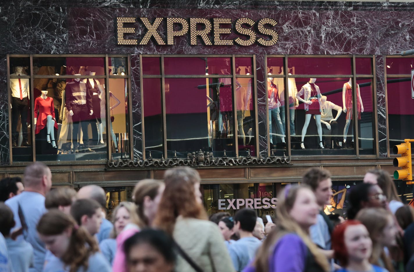 People walk by an Express store in New York's Times Square. (AP Photo/Bebeto Matthews)