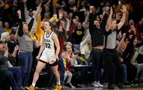 Iowa guard Caitlin Clark (22) reacts after breaking the NCAA women's career scoring record during the first half of the team's college basketball game