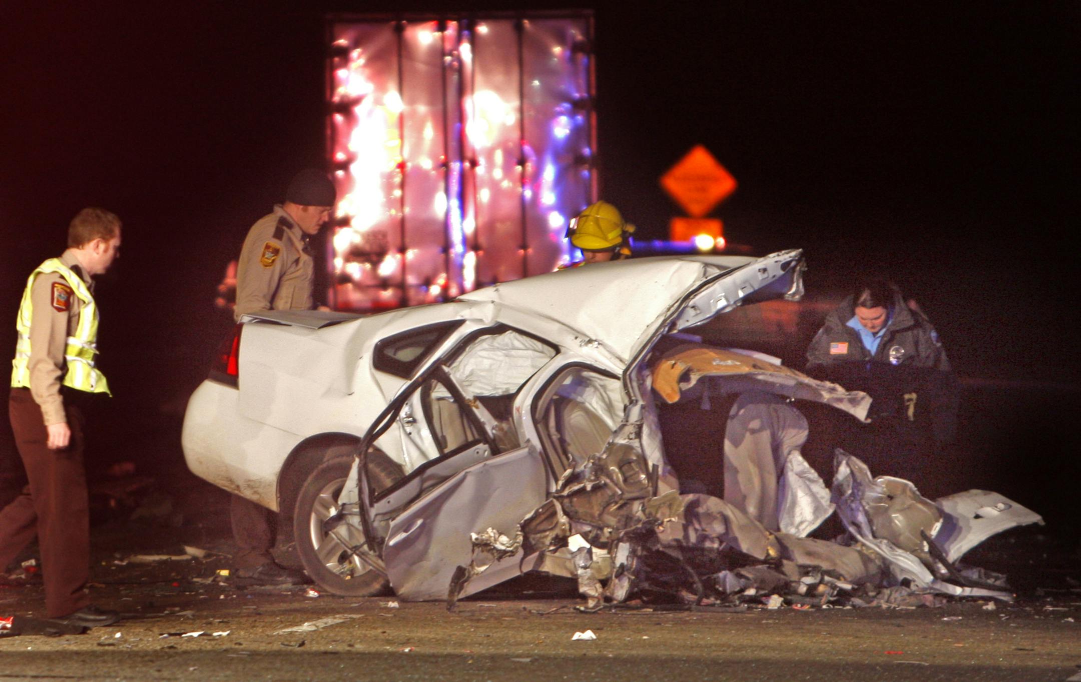 Minnesota State Highway Patrol and other emergency personel examine the wreckage of a vehicle hit by a semi tuck on Hwy 52 at Zumbrota Friday night. Two people were confirmed dead at the scene and another critically injured.