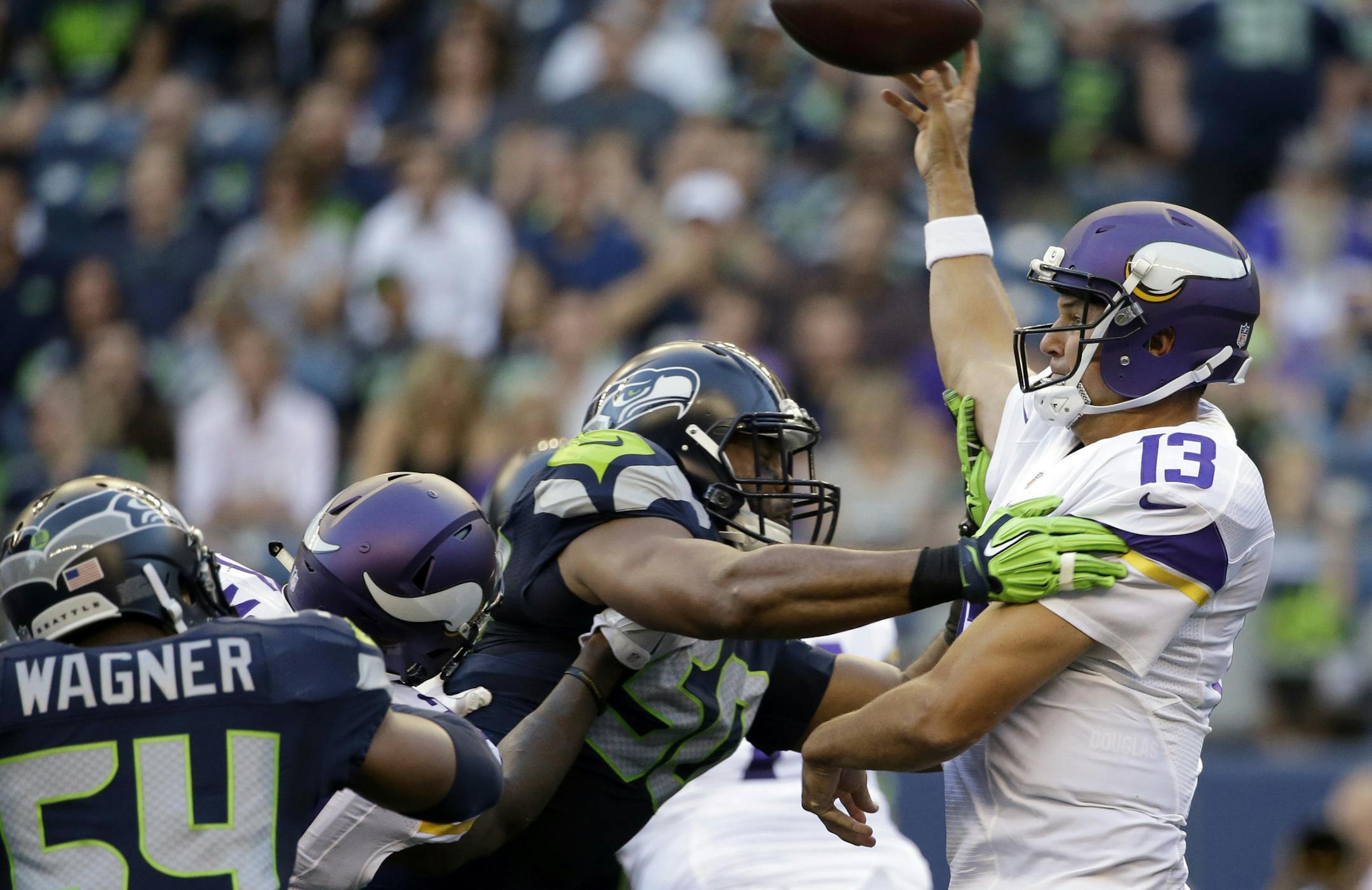 Minnesota Vikings quarterback Shaun Hill, right, is pressured by Seattle Seahawks outside linebacker K.J. Wright, center, and middle linebacker Bobby Wagner (54) during the first half of a preseason NFL football game, Thursday, Aug. 18, 2016, in Seattle. (AP Photo/Elaine Thompson)
