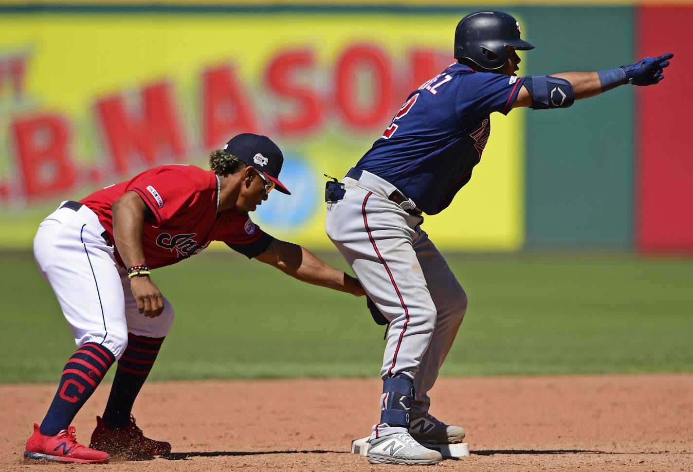 Minnesota Twins' Luis Arraez, right, celebrates after hitting a double in the eighth inning of a baseball game against the Cleveland Indians, Sunday, July 14, 2019, in Cleveland. (AP Photo/David Dermer)