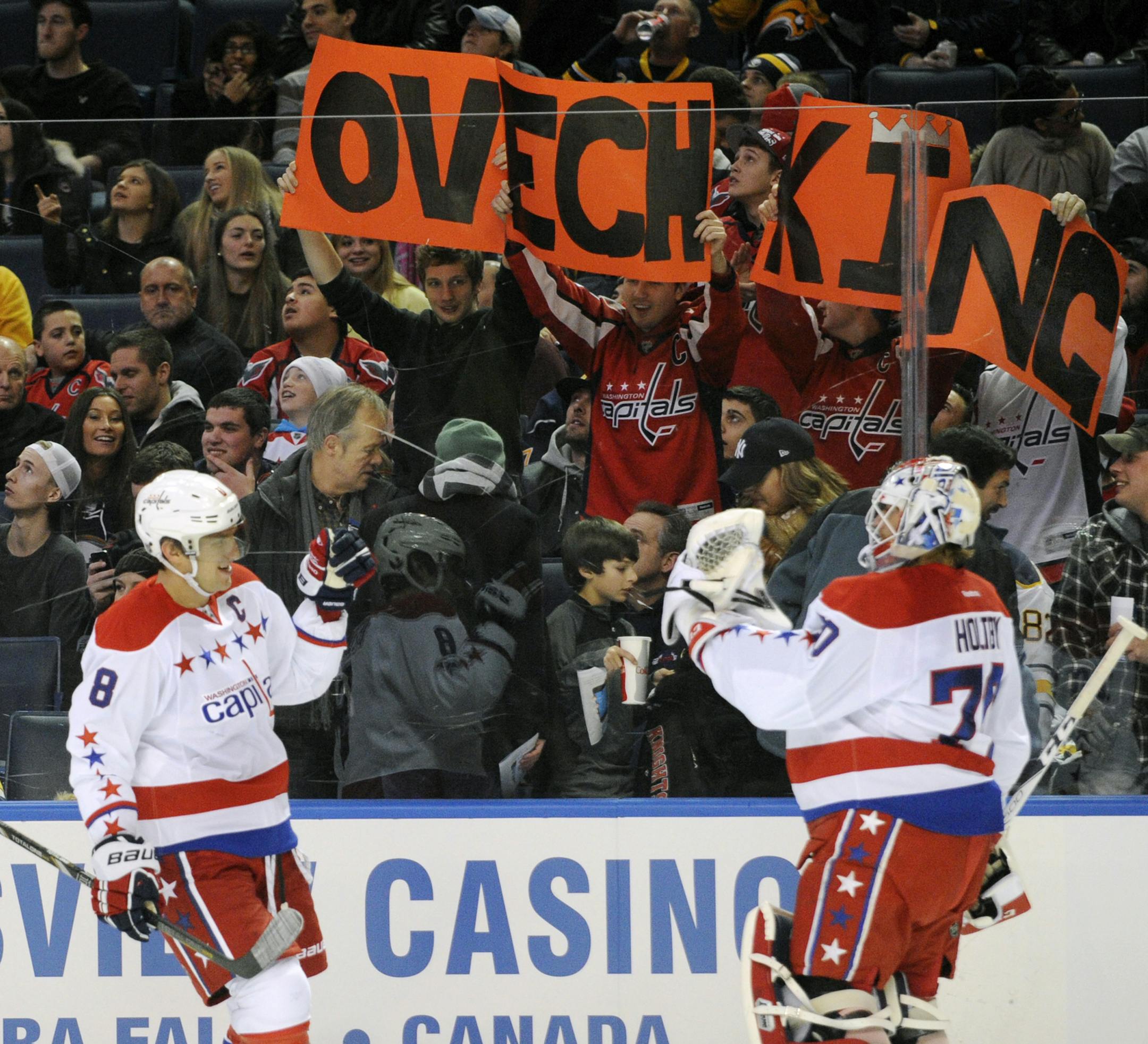 Washington Capitals' Alex Ovechkin (8) of Russia, celebrates his second goal with Braden Holtby (70) and Washington fans during the first period of an NHL hockey game against the Buffalo Sabres in Buffalo, N.Y., Tuesday, Jan. 28, 2014. (AP Photo/Gary Wiepert)