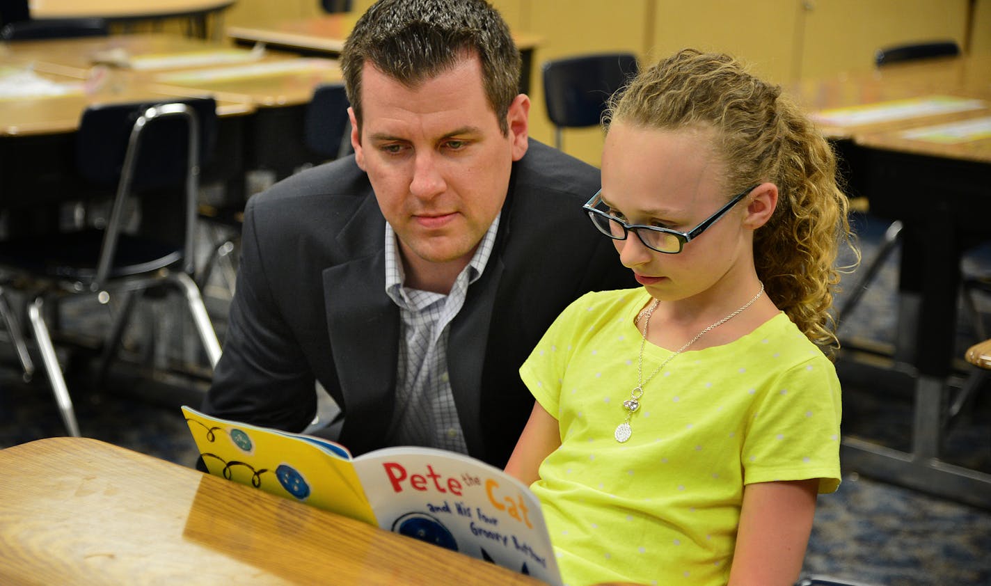 Mike Yanisch, 33, Bremer bank manager in Arden Hills is a long-time classroom volunteer at Liberty Ridge Elementary he looked on as Ava Matza a third grader read in a classroom . ] Richard.Sennott@startribune.com Richard Sennott/Star Tribune Woodbury Minn. Tuesday 5/20/2014) ** (cq)