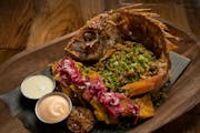 The Pescado Frito; fried red snapper, with coconut rice, pickled cabbage, grilled lime, patacones, and cotija at Guacaya Bistreaux in Minneapolis.