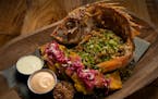 The Pescado Frito; fried red snapper, with coconut rice, pickled cabbage, grilled lime, patacones, and cotija at Guacaya Bistreaux in Minneapolis.
