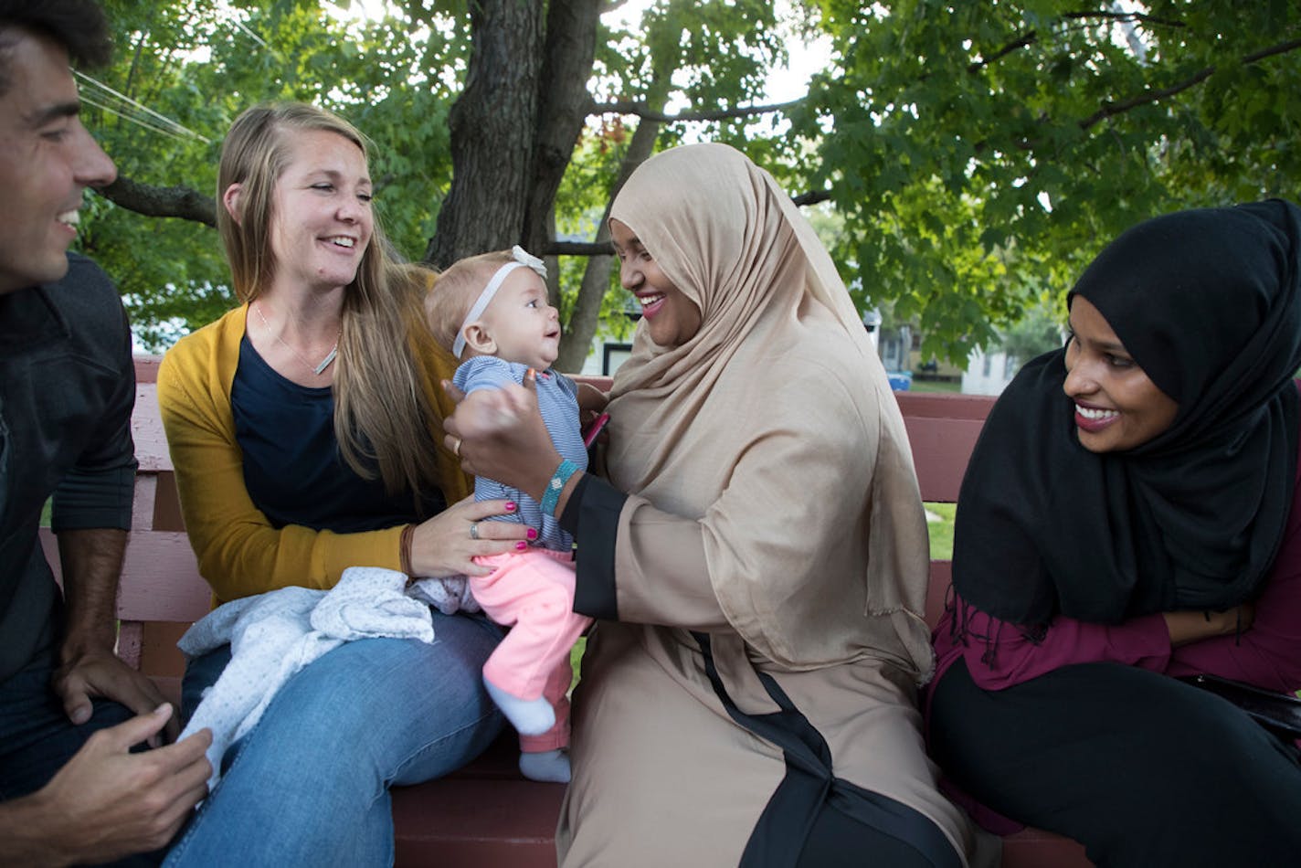 St. Cloud Mayor Dave Kleis started holding monthly dinners at his house two years ago to get neighbors talking to one another and start conversations in the community. At a September 2017 dinner, Joshua Johnson and his wife Rachel Johnson (left) looked on as Ayan Abdi played with Tatum, their 5 -month old daughter, next to Nimo Ahmed.