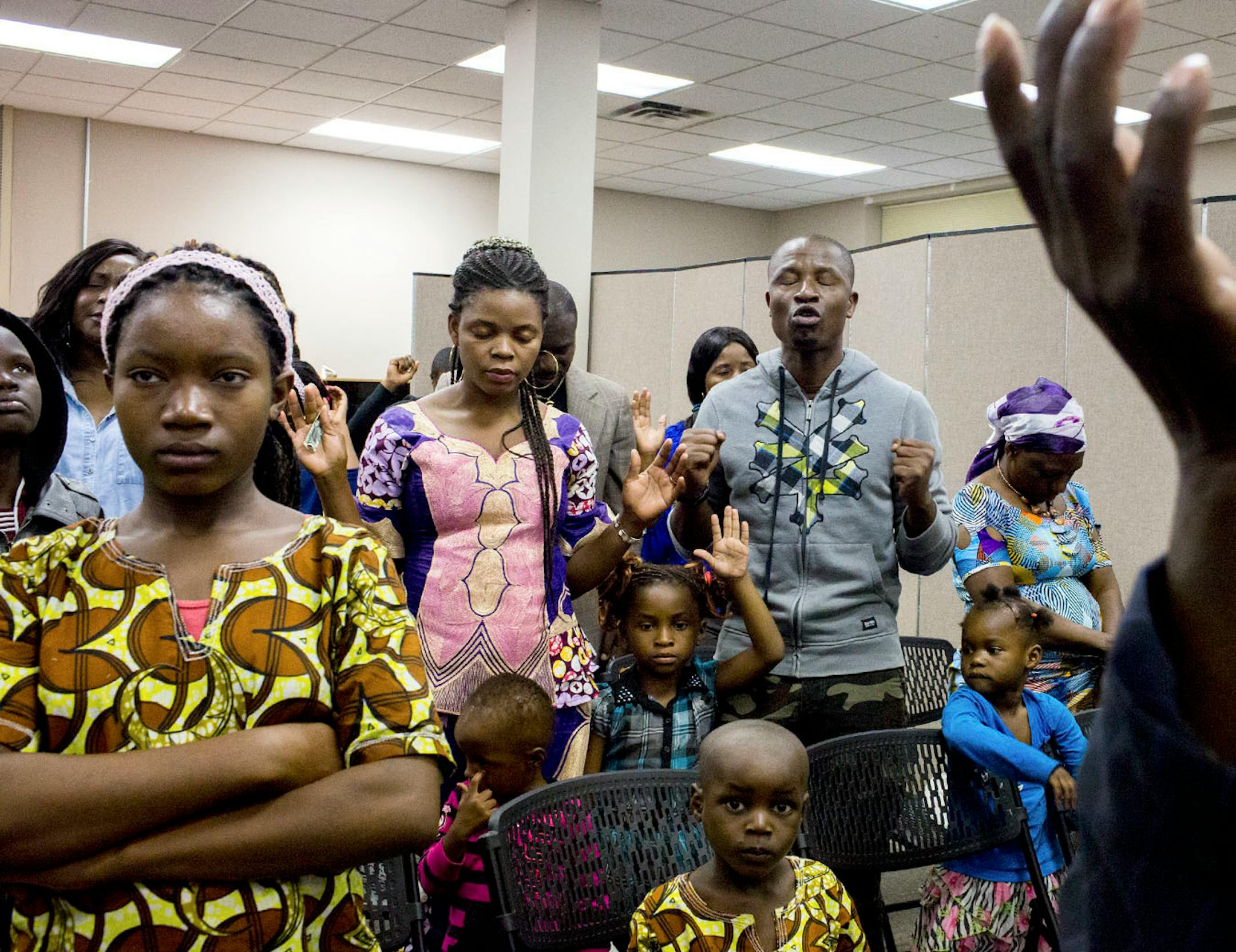 The members of the church service for African refugees listen and pray with the preaching, at Bethel Christian Fellowship Church.