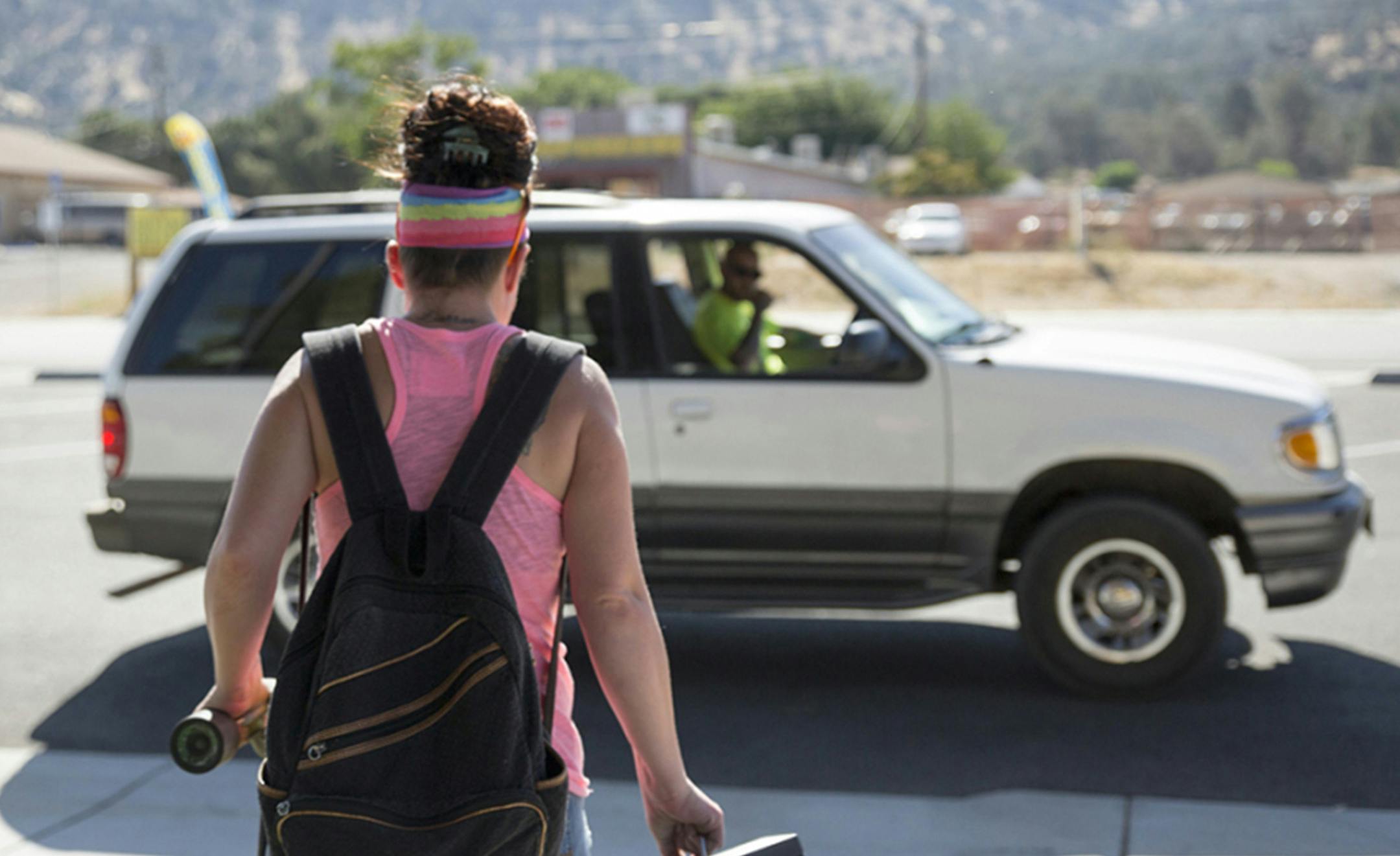 After riding the bus to the methadone clinic, Heather Menzel gets picked up by her brother at the bus stop in Lake Isabella, Calif., on June 6, 2016. (Brian Rinker for KHN)
