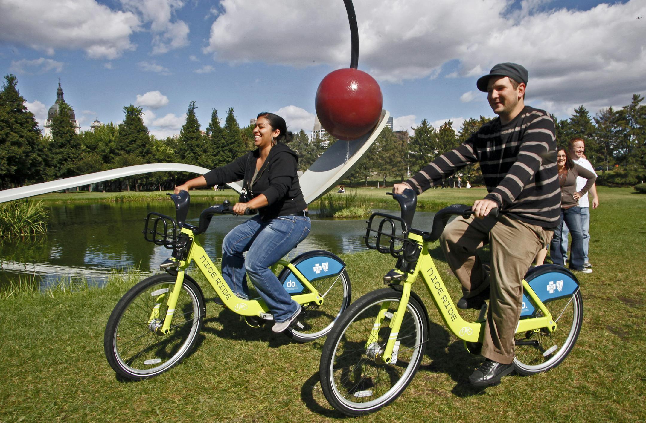 MARLIN LEVISON * mlevison@startribune.com September 4, 2010 - GENERAL INFORMATION: Minneapolis bike rental program called Nice Rides has been a huge success with bikes being rented out of the city racks at near capacity levels. IN THIS PHOTO: ] Veronica Mendez of Minneapolis, left and Dan P. Moore of Cincinnati OH. rode Nice Bikes past the Spoonbridge and Cherry sculpture in the Minneapolis Sculpture Garden.