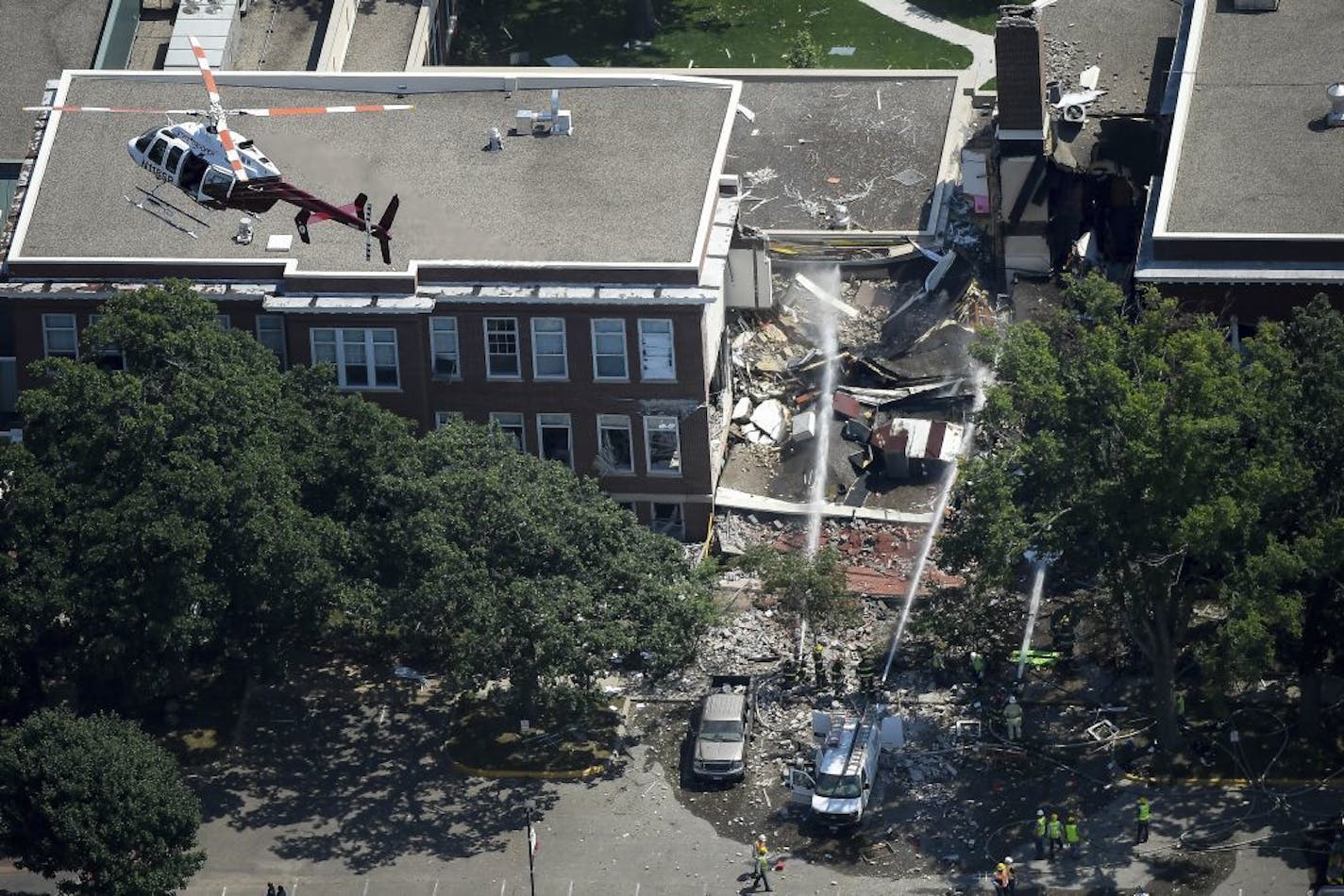 FILE - In this Aug. 2, 2017 file photo, emergency workers respond to an explosion at Minnehaha Academy in Minneapolis. A preliminary report released Monday, Aug. 21, 2017, by the National Transportation Safety Board about the school explosion, says a maintenance worker smelled natural gas and used a radio to tell others to evacuate just a minute before the blast. Two people died when part of a building collapsed.