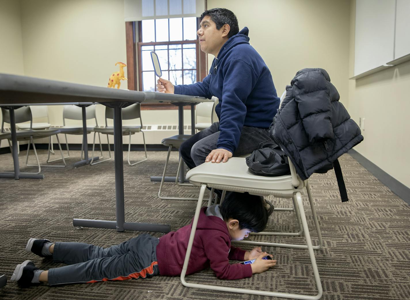 Federico Cano listened to his teacher as his son Yeray, 4, kept busy on his father's smartphone during an ESL class at the University of Minnesota, Morris.