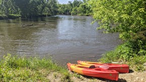 Two kayaks provided by the Gear ReSource Outfitters waited on the shore of the Cannon River near Faribault, Minn.