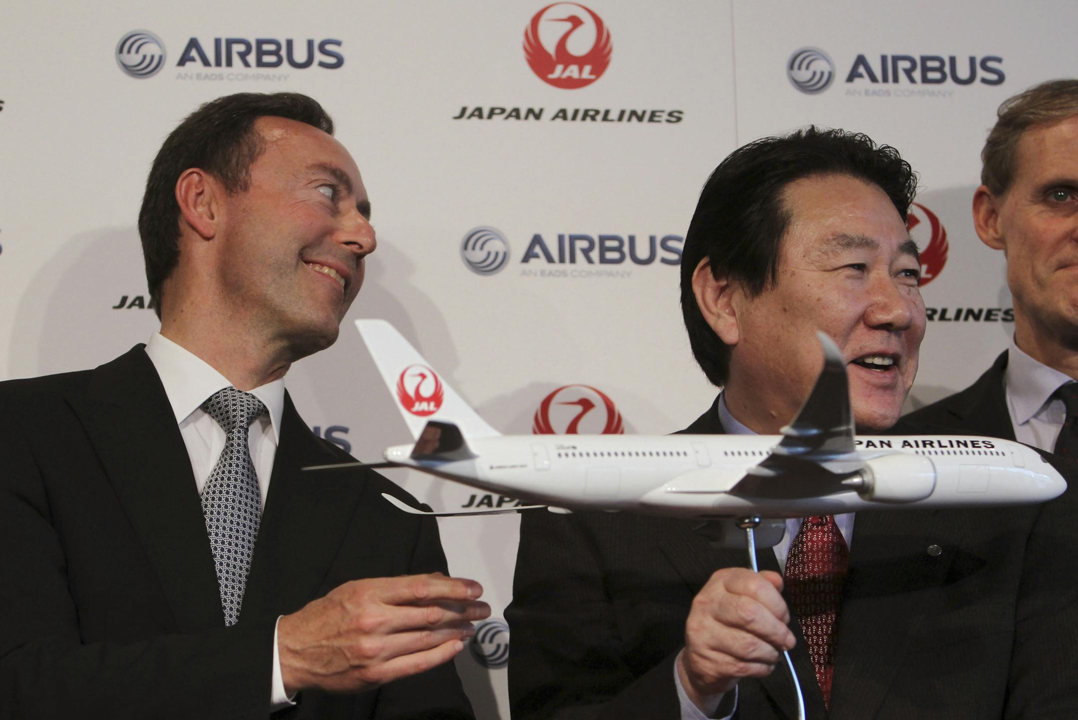 Airbus Japan Chief Executive Fabrice Bregier, left, and Japan Airlines President Yoshiharu Ueki, right, hold a model plane of Airbus A350 following their press conference in Tokyo, Monday, Oct. 7, 2013. Japan Airlines is buying its first ever jets from Airbus in a deal with a catalog value of 950 billion yen ($9.5 billion) with a purchase of 31 A350 planes. (AP Photo/Junji Kurokawa) ORG XMIT: MIN2013101414550729