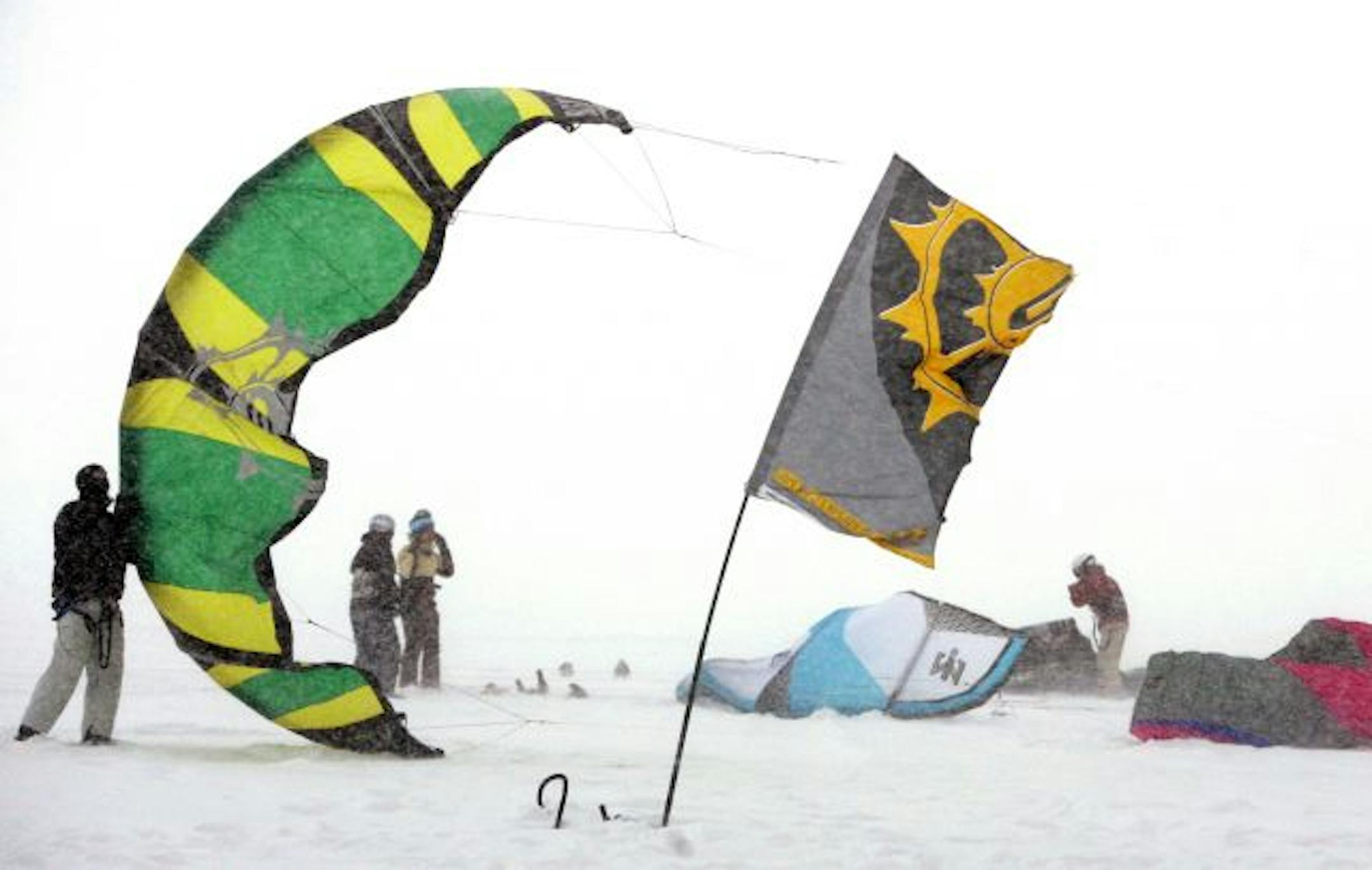 Mike Kratochwill, left, helped a fellow snowkiter launch a kite on White Bear Lake in Mahtomedi Saturday, Dec. 20, 2008. Snowkiting is done by using a large kite or wing to pull a skiier or snowboarder across the snow.