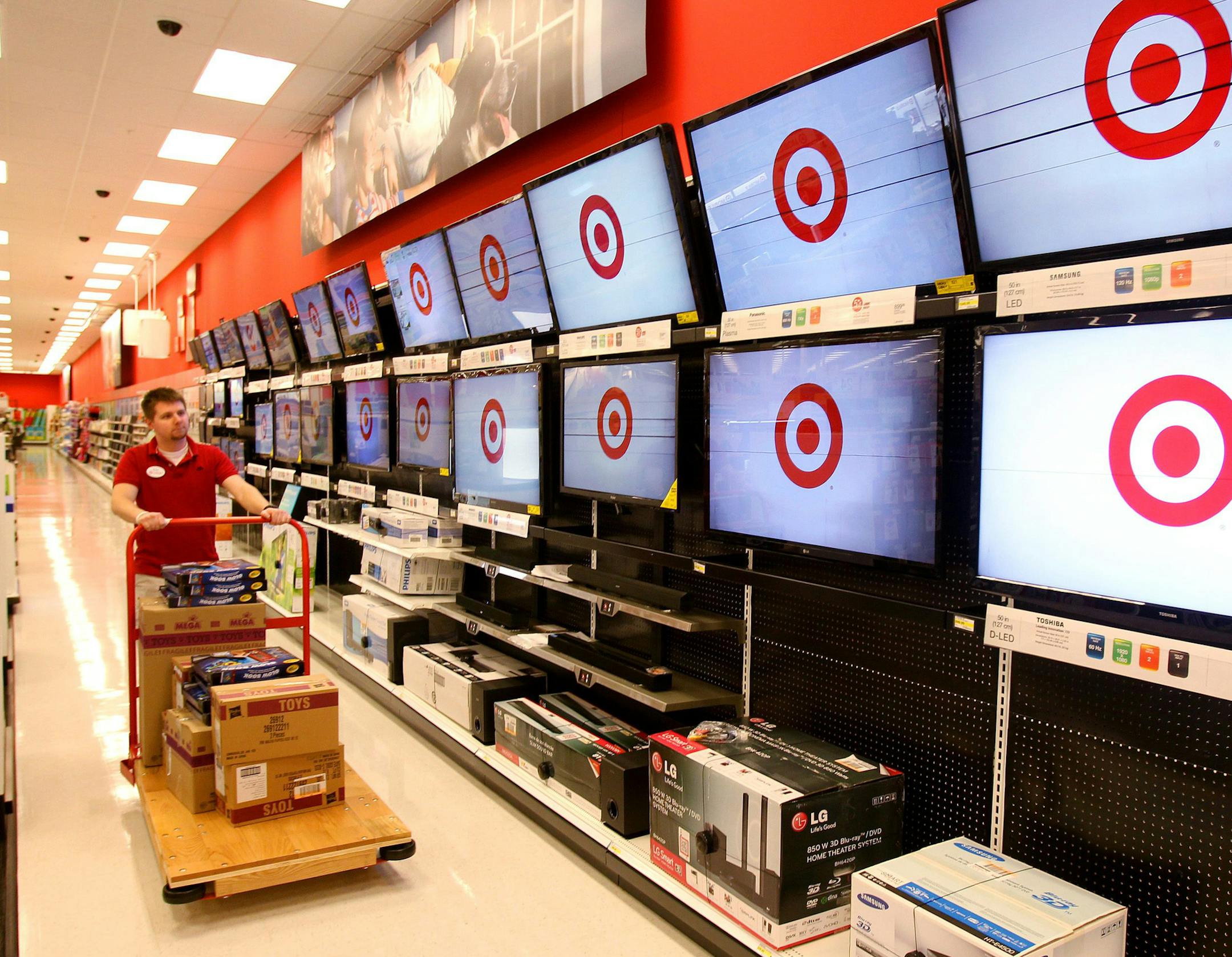 Brian Beeksma pushes a cart of goods as employees work on preparing the new Target store in Guelph, Ontario. Target announced that it is opening three pilot stores in Guelph, Fergus and Milton, Ontario March 5, 2013, the first of 124 Target stores to open in Canada, Media were given a preview tour, Monday, March 4, 2013. (AP Photo/The Canadian Press, Dave Chidley) ORG XMIT: CPOTK
