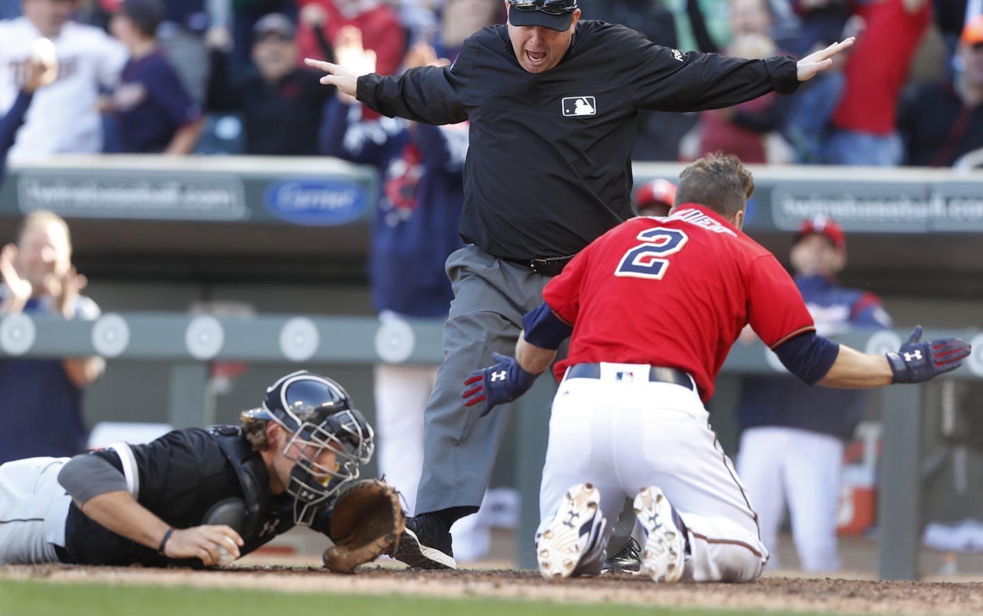 Minnesota Twins second baseman Brian Dozier (2) was called safe by umpire Todd Tichenor after diving past Sox catcher Kevan Smith for an inside the park homer in the firth inning at Target Filed Sunday.