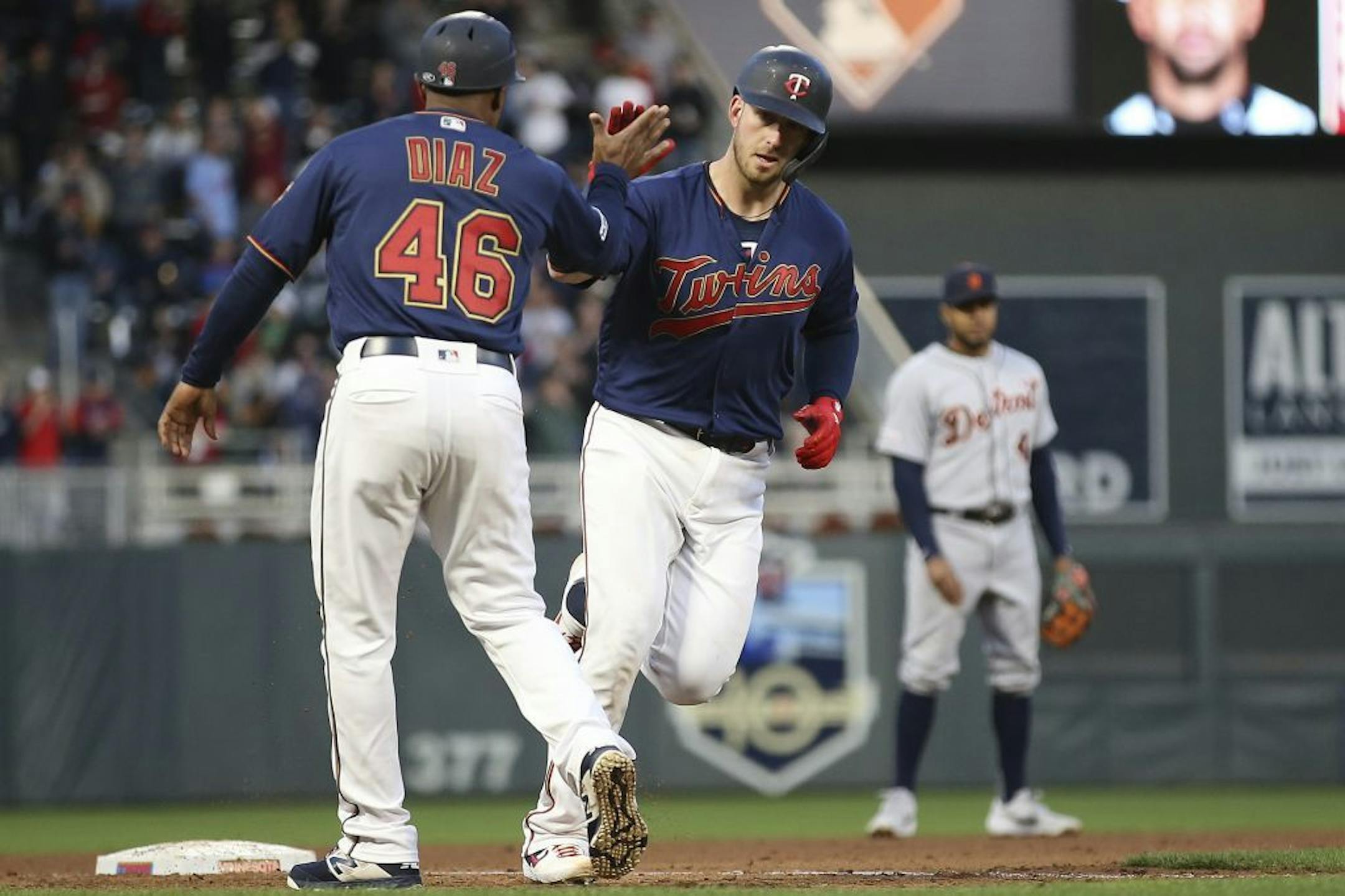 Minnesota Twins' Mitch Garver high-fives third base coach Tony Diaz after he hit a home run against the Detroit Tigers during the fourth inning of a baseball game Friday, May 10, 2019, in Minneapolis.